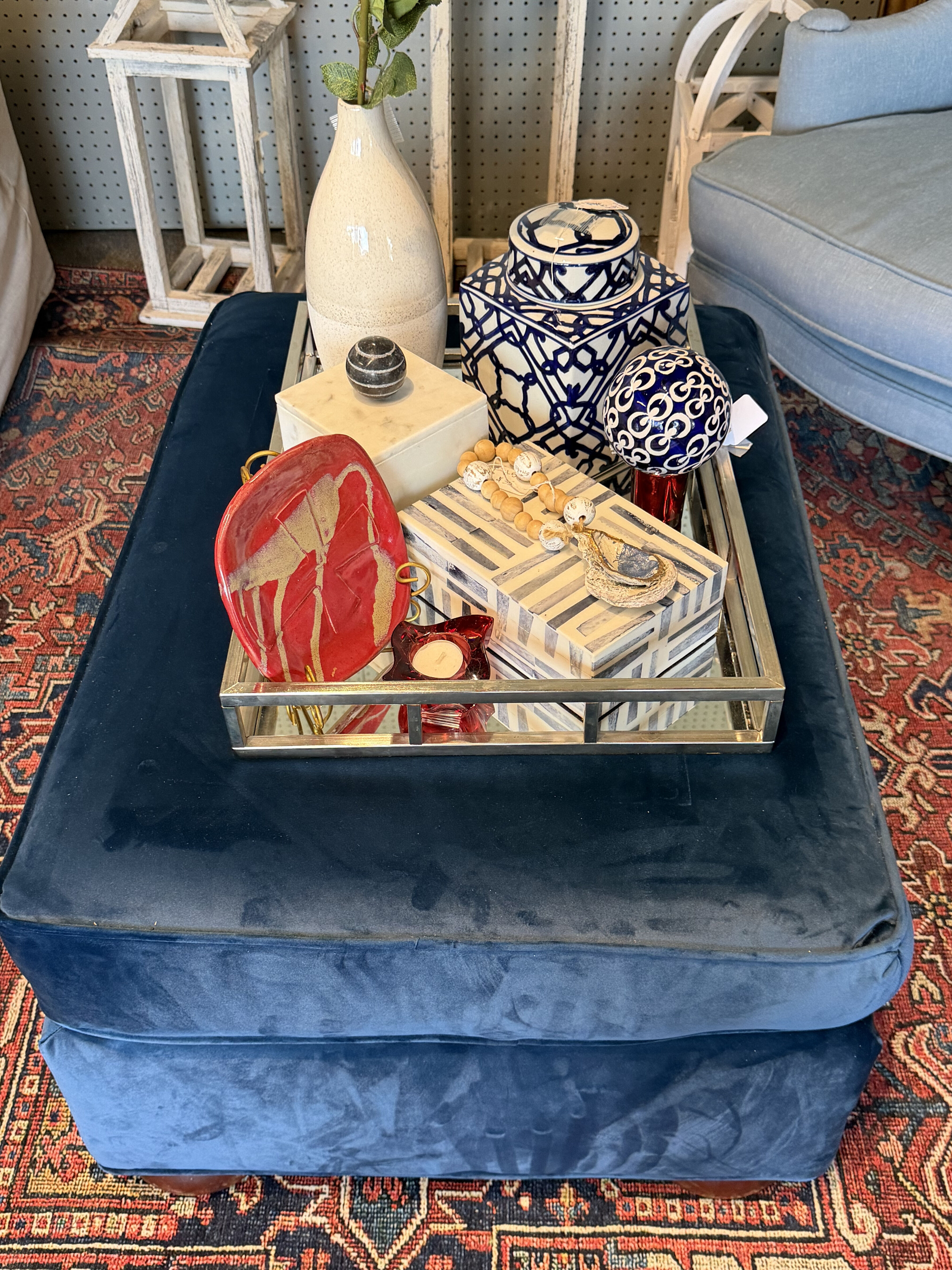 Blue velvet ottoman with curated decor