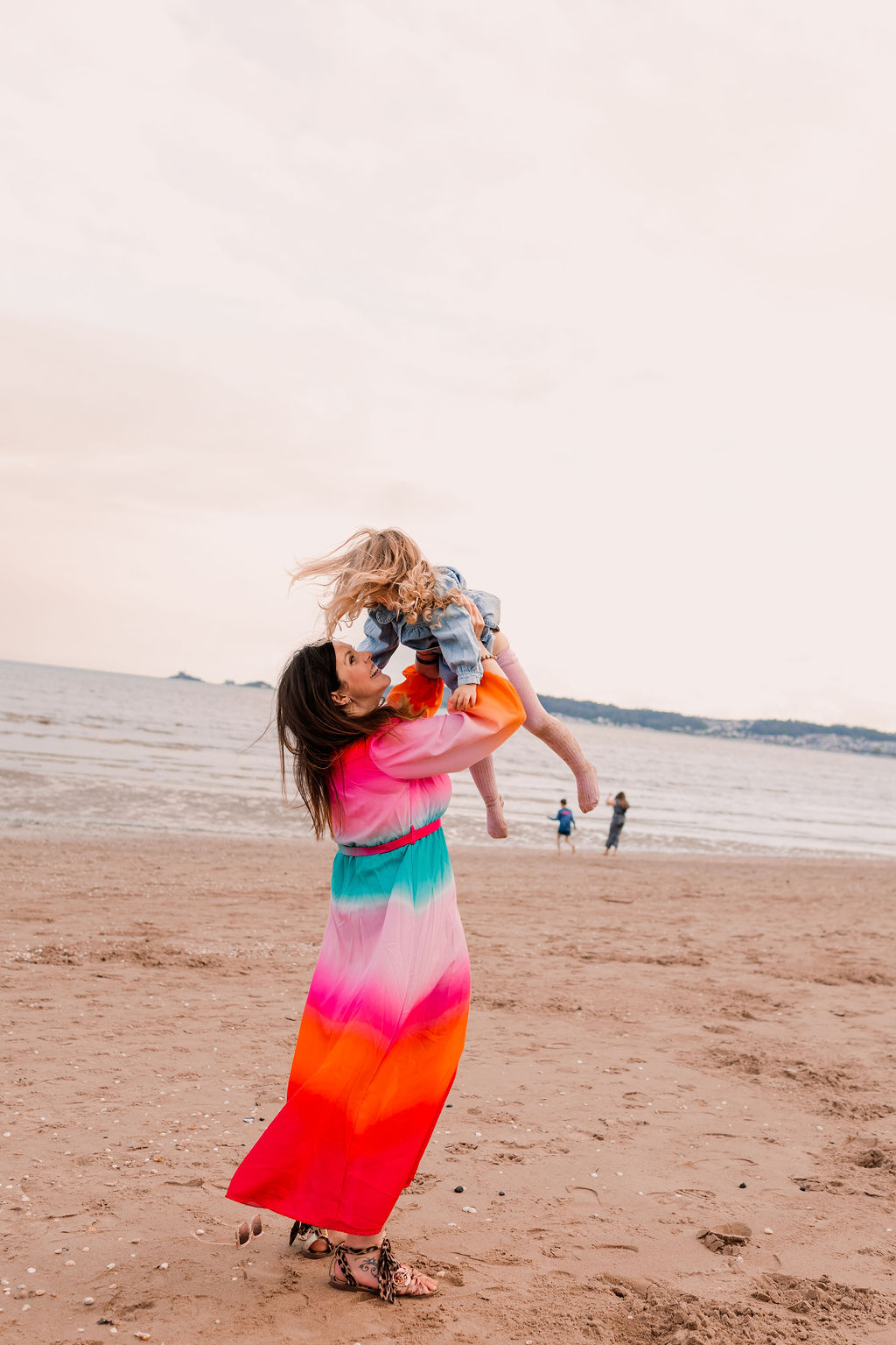 Beth lifting her daughter on the beach