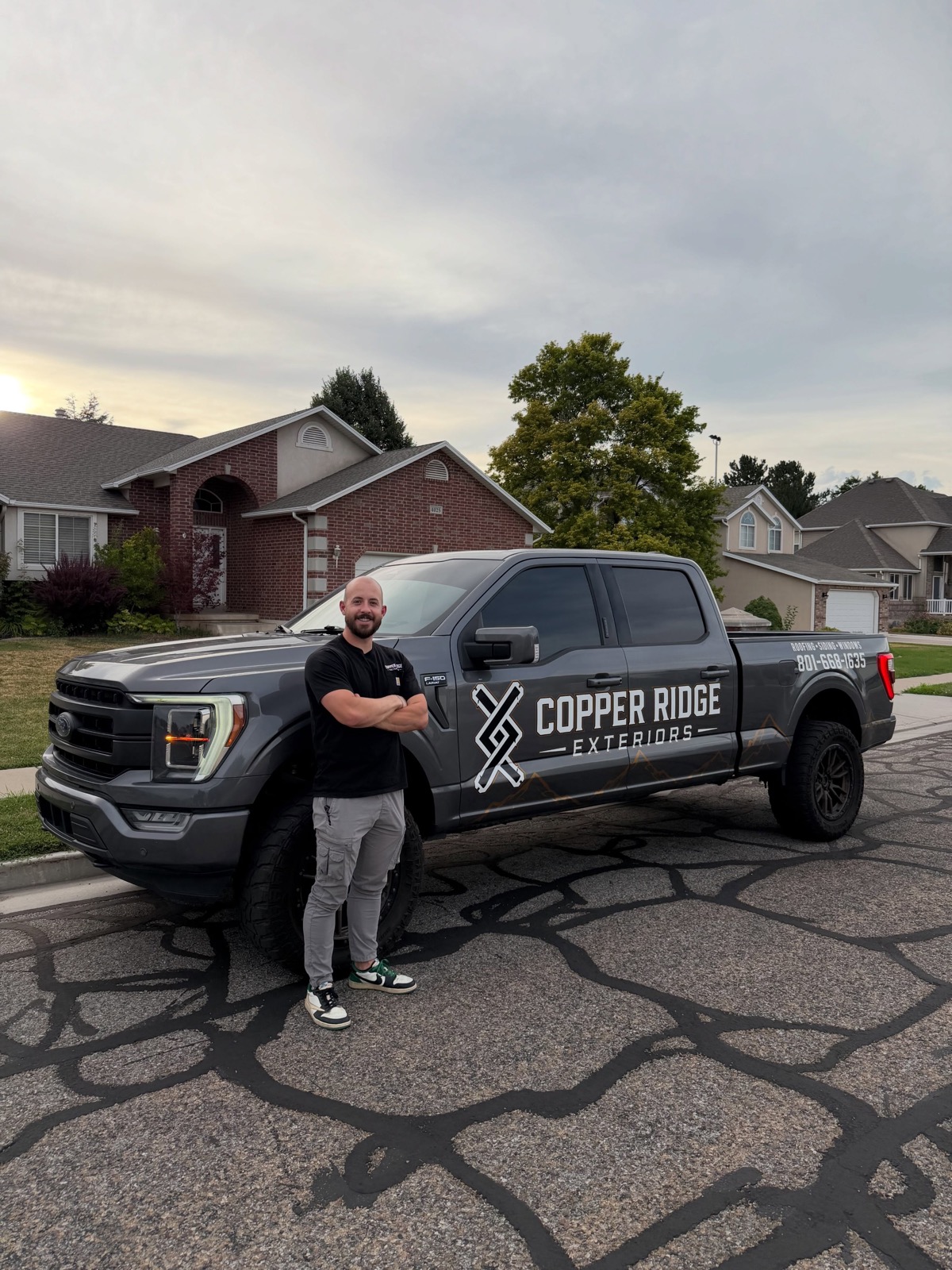 Bryce Wheeler, owner of Copper Ridge Exteriors, standing beside the company truck