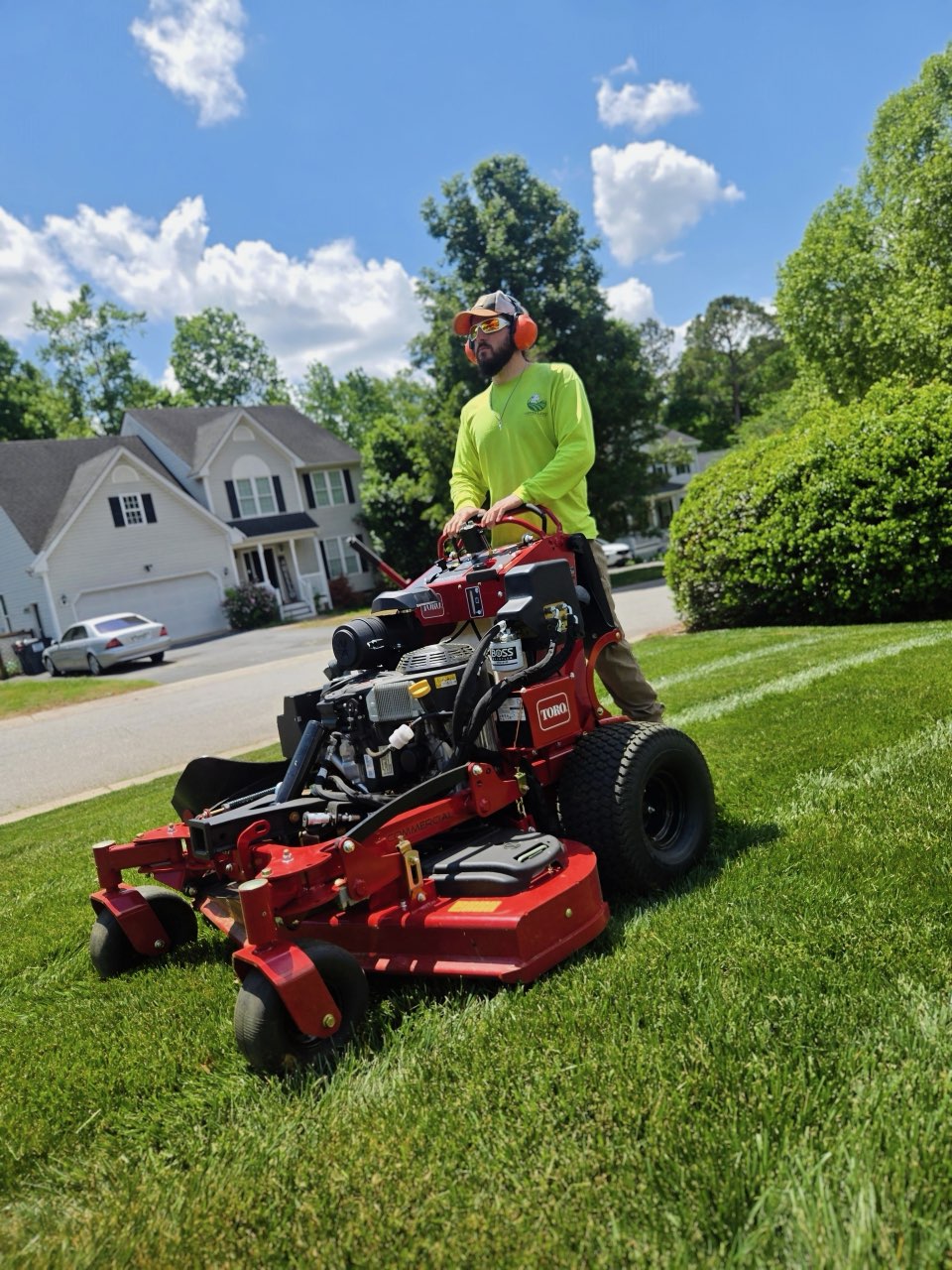 Green Land crew member on a stand-on mower
