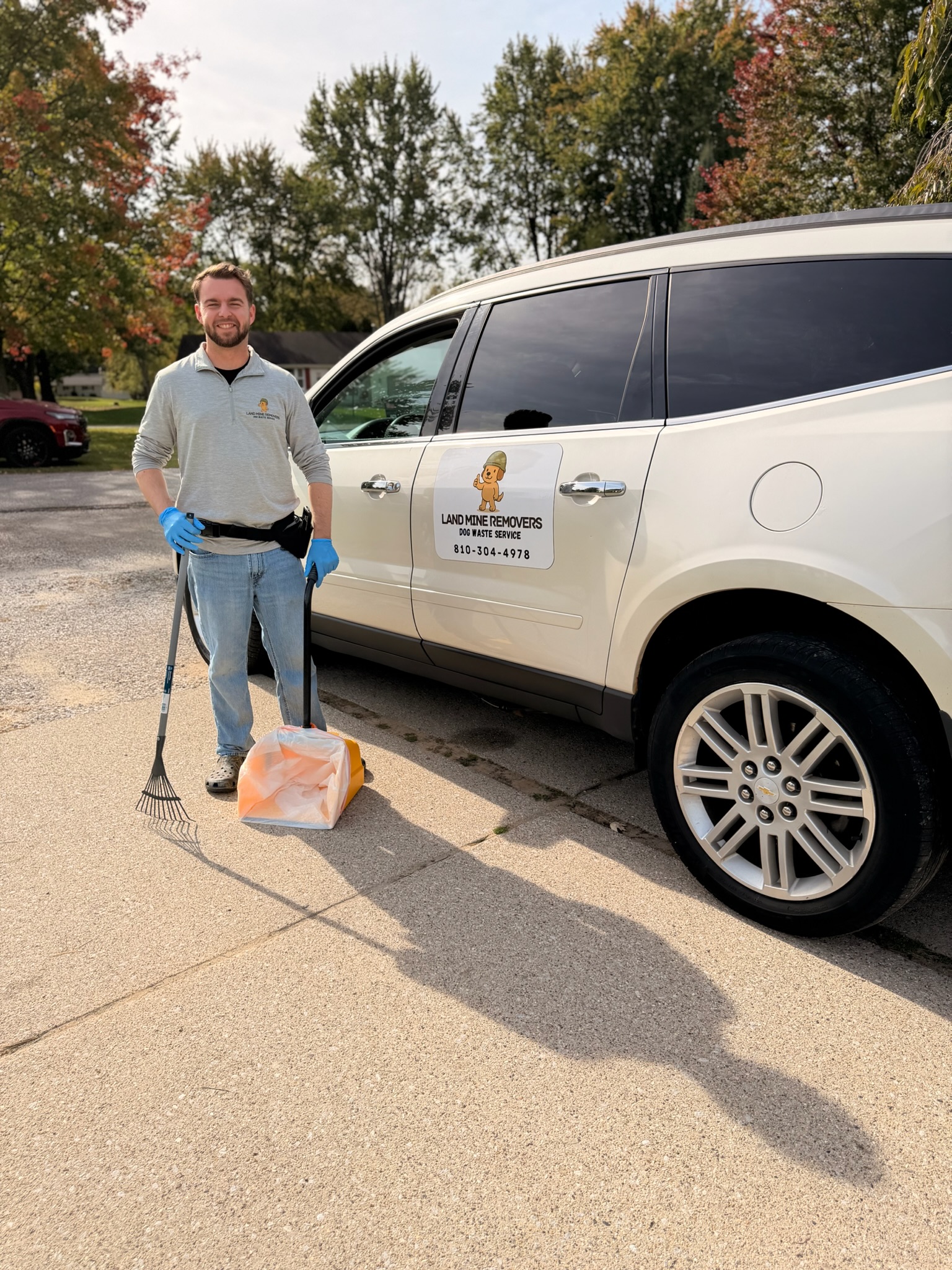 Brenden ready with sanitized scoop and rake beside the Land Mine Removers vehicle