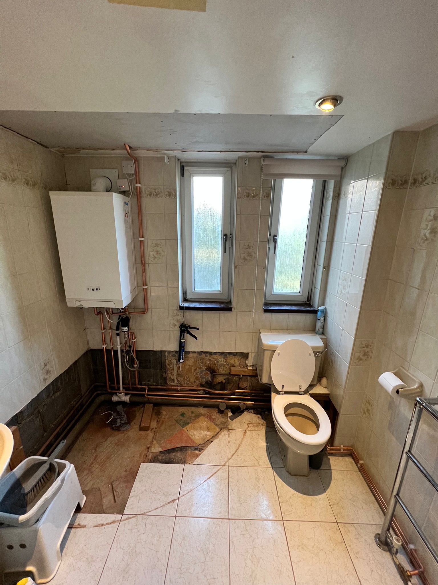 Boiler and pipework in bathroom during renovation