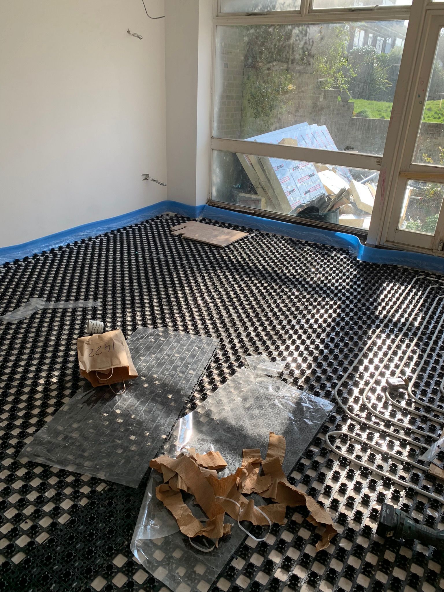 Underfloor heating pipework layout in a room with a large window