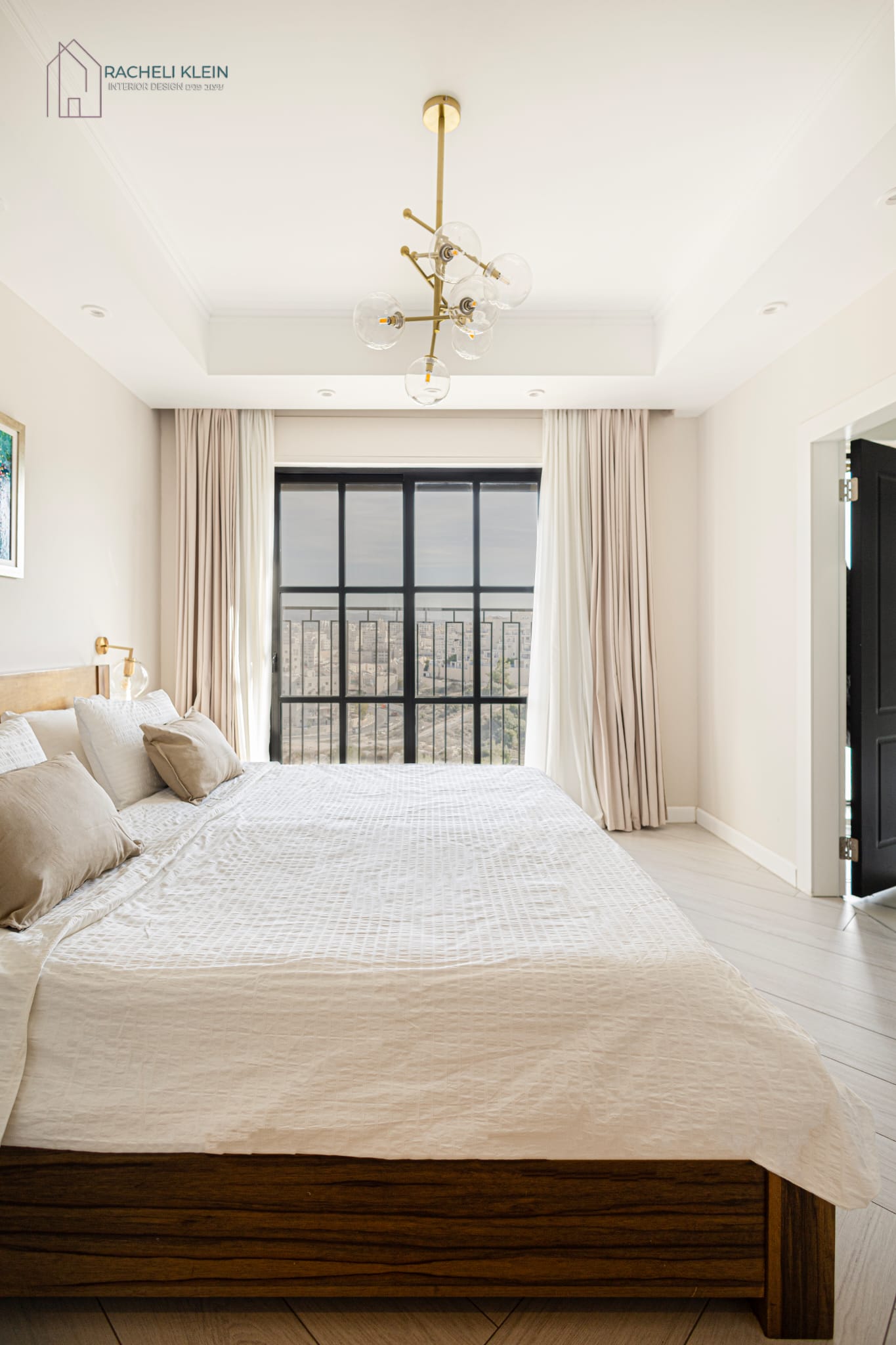 Bright bedroom with large window and modern chandelier