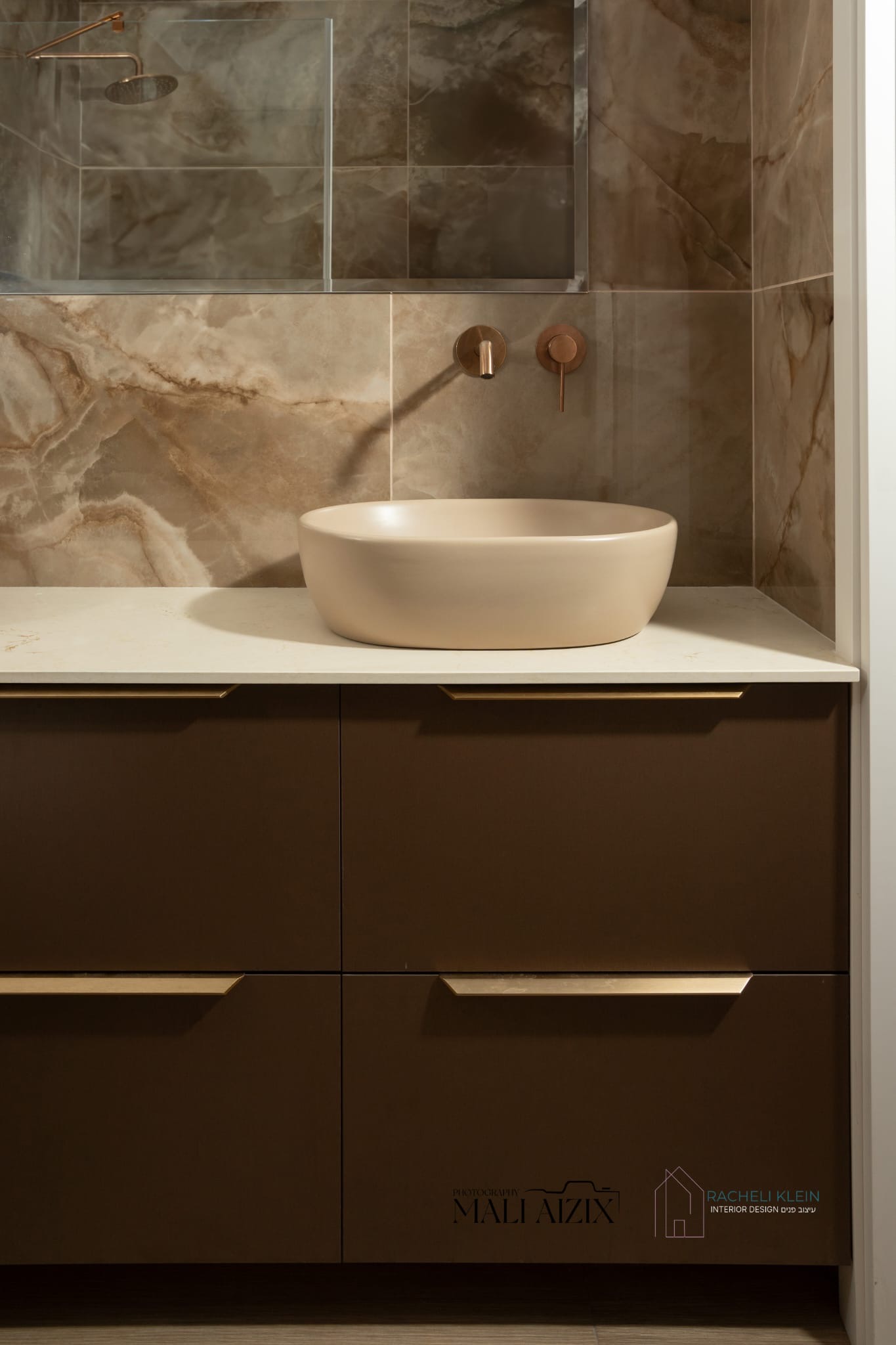 Custom bathroom design in Israel with brown cabinet and textured wall by Racheli Klein