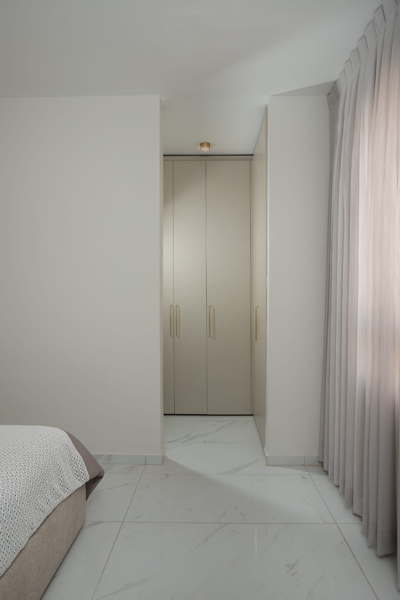 Minimalist bedroom with built-in wardrobe and light tones