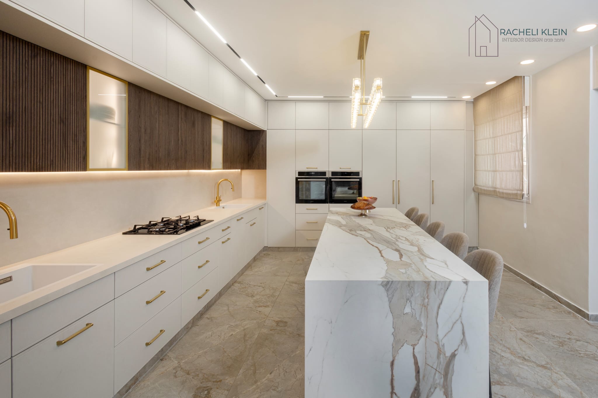 Modern kitchen with long glass chandelier and marble island