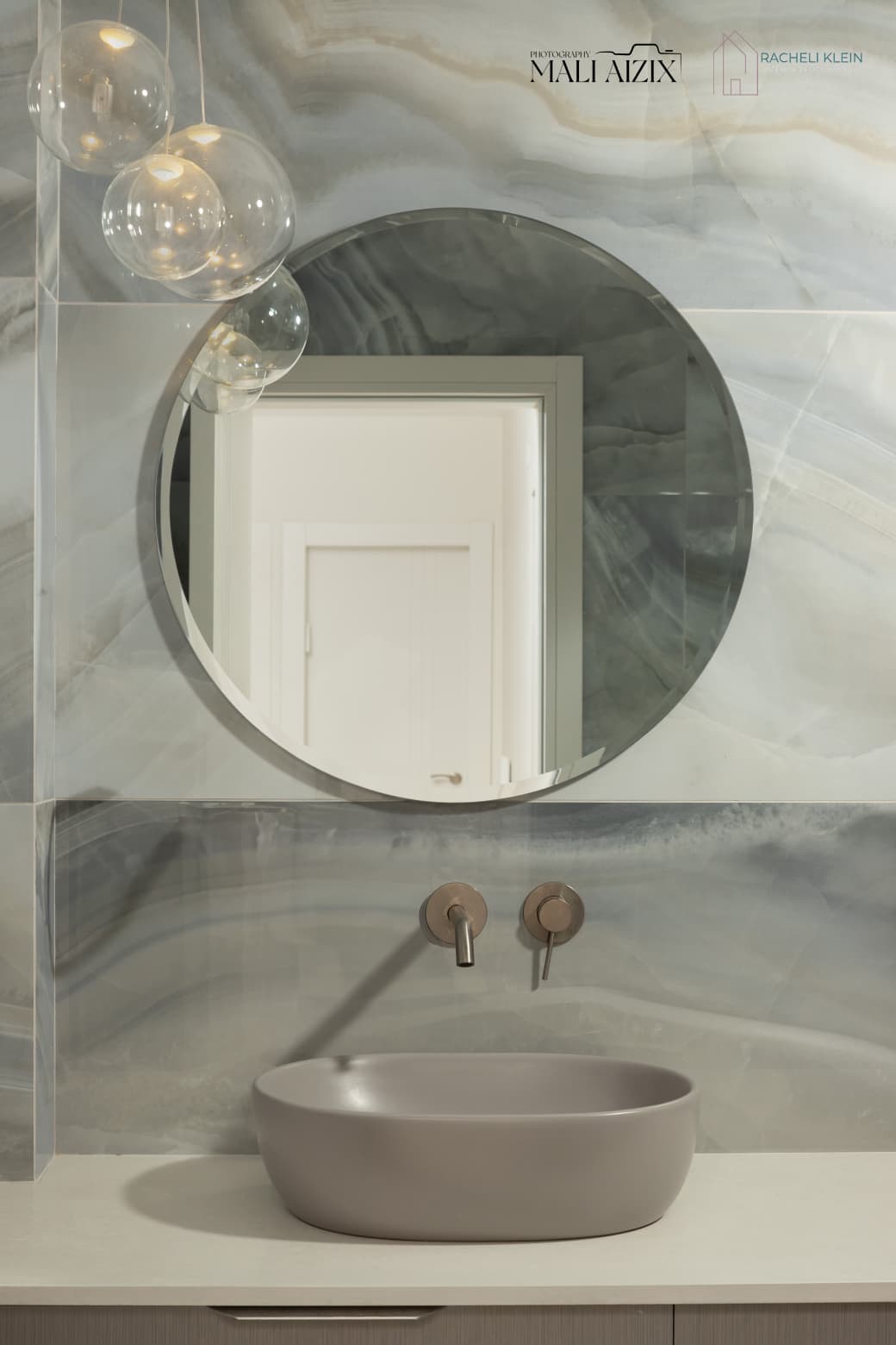 Round mirror above bathroom sink with blue marble wall — bathroom interior design in Bet Shemesh
