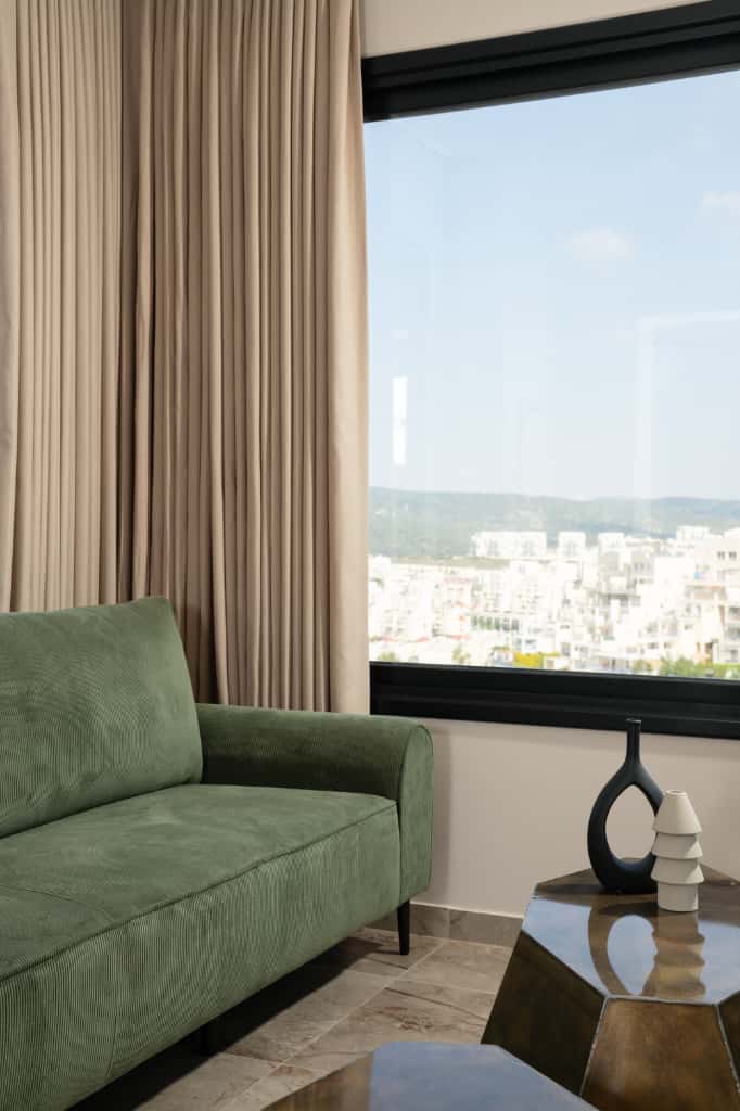 Living room with green sofa and view