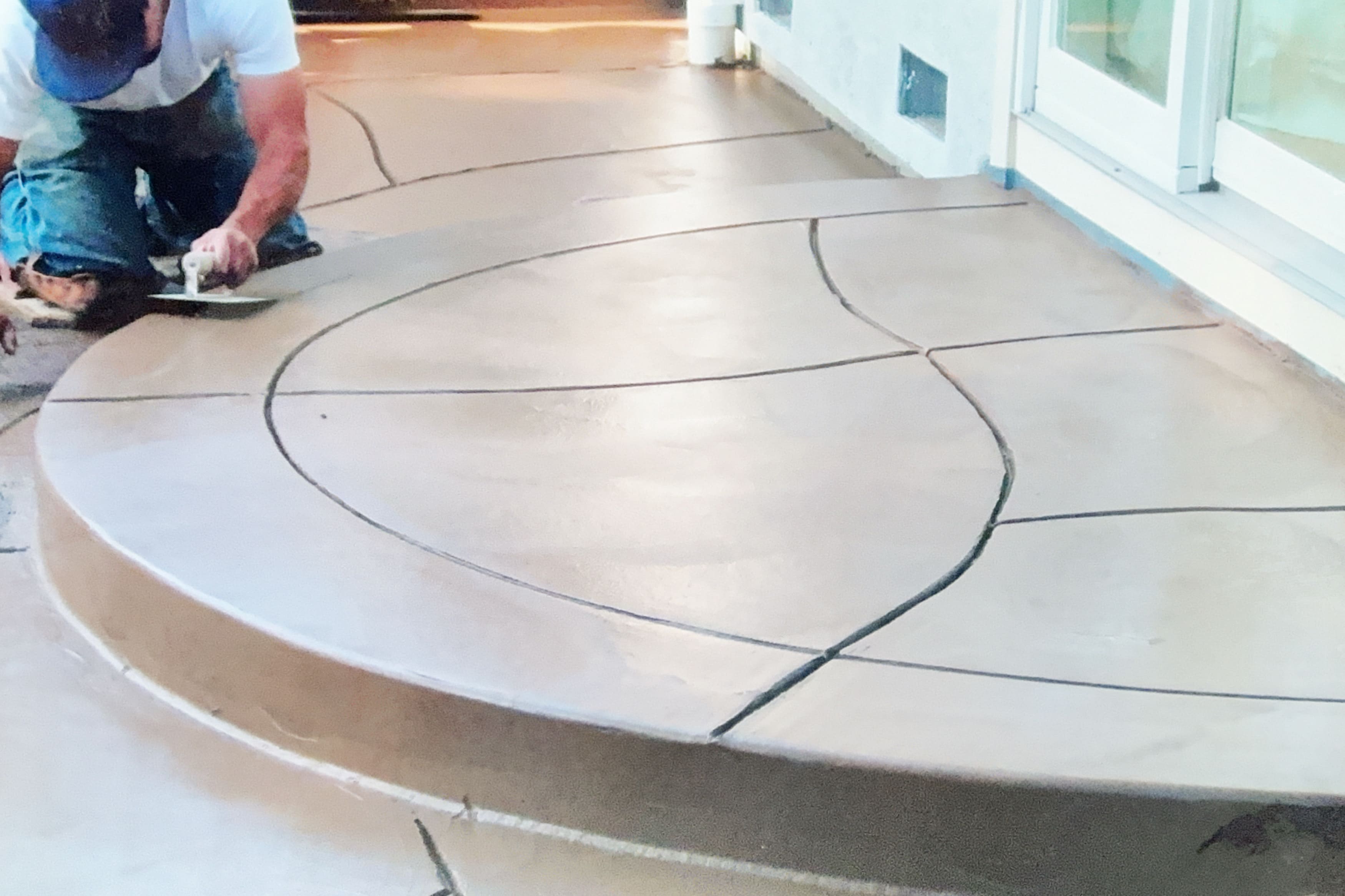 Worker smoothing out a decorative concrete patio surface