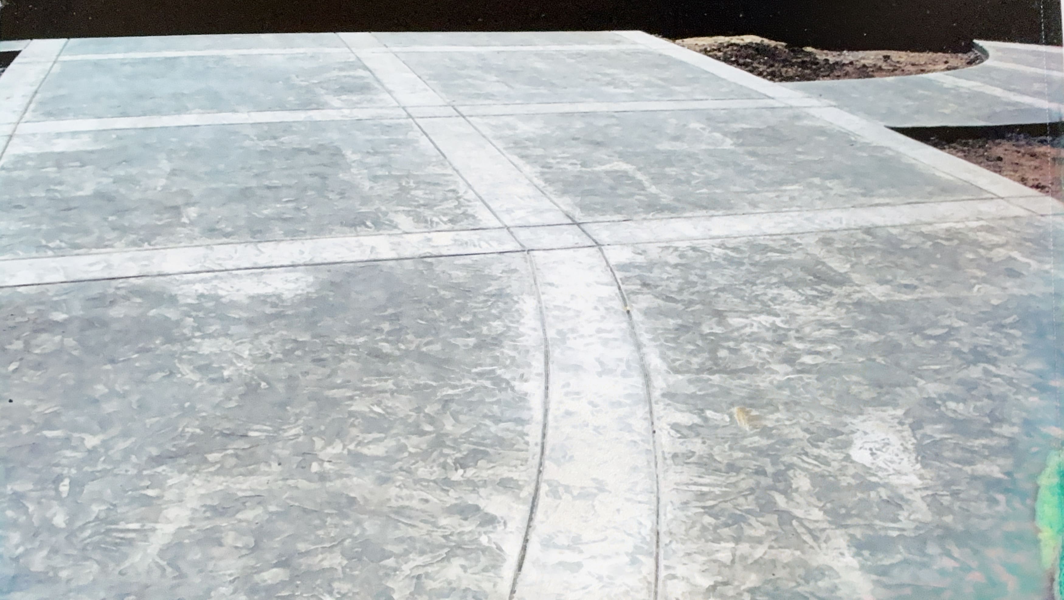 Close-up of a smooth concrete surface with decorative expansion joints forming a grid pattern