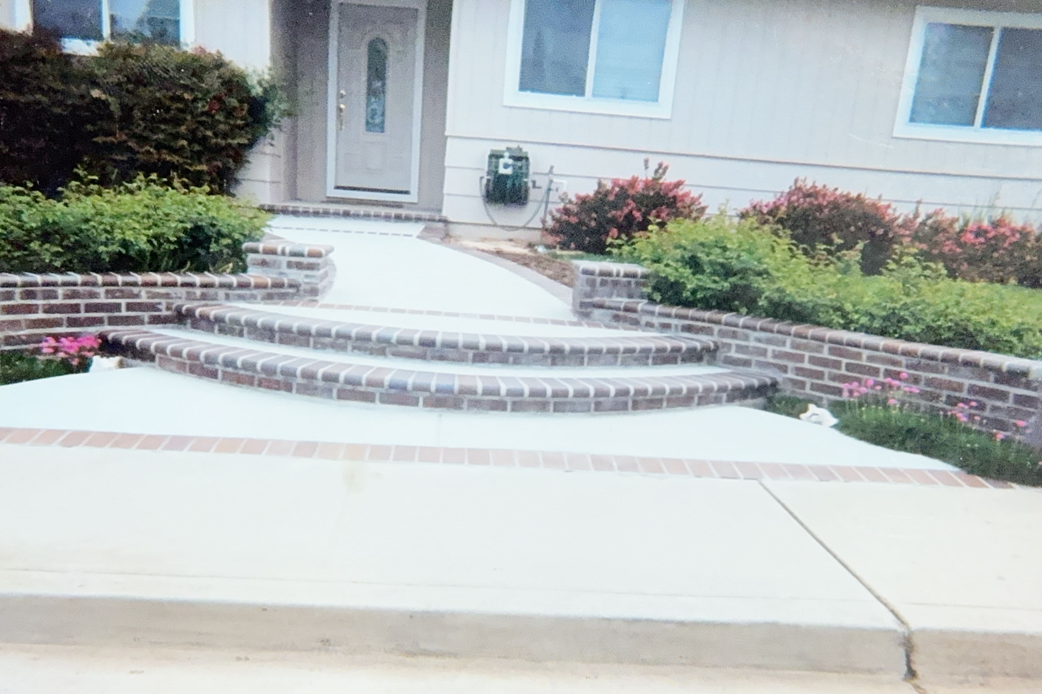 Curved brick and concrete steps leading to home entrance