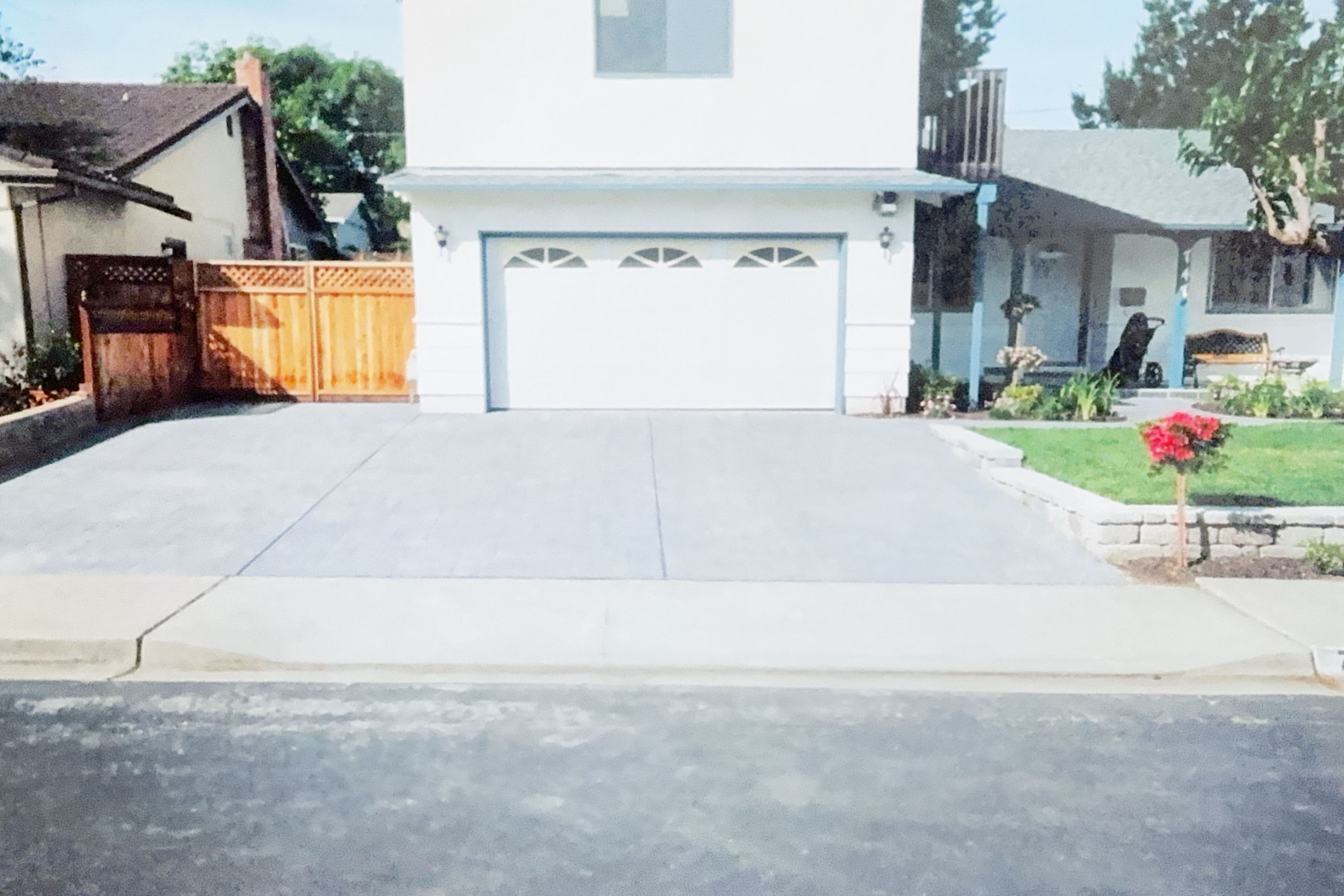 Clean, newly poured concrete driveway in front of a house with a garage