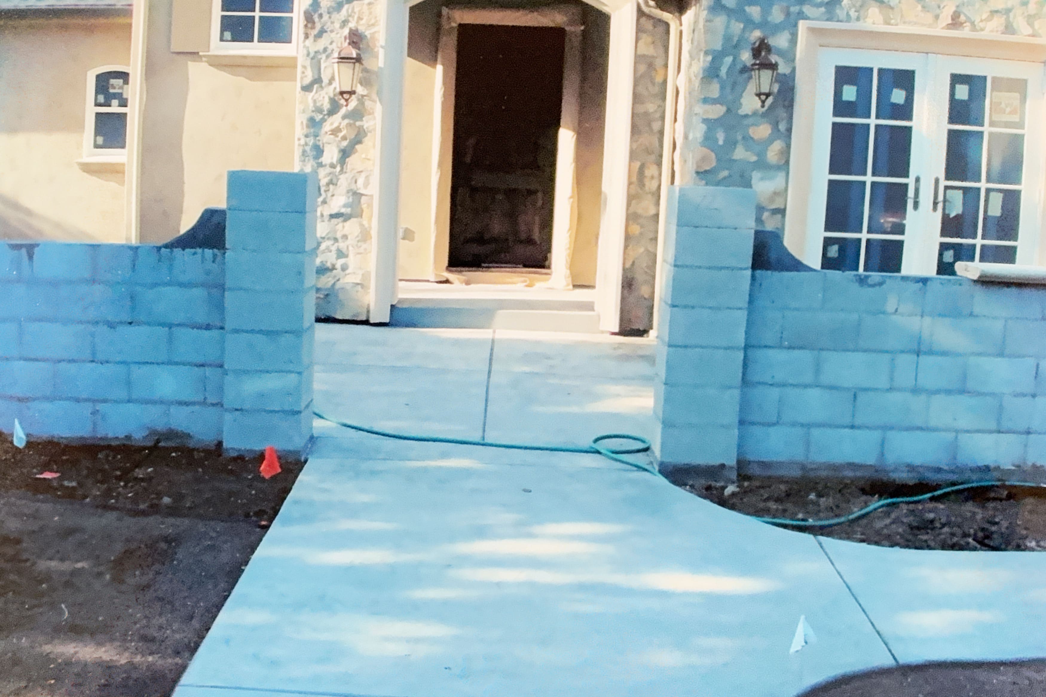 Front entrance concrete walkway with low cinder block walls
