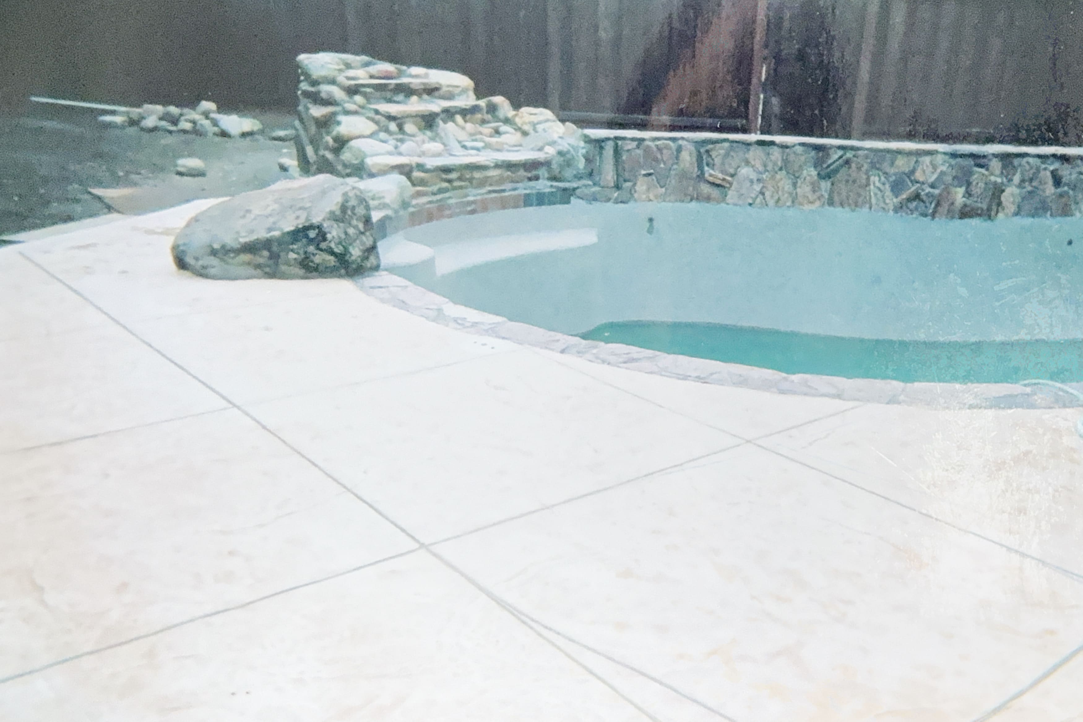 Pool under construction with custom stone waterfall feature