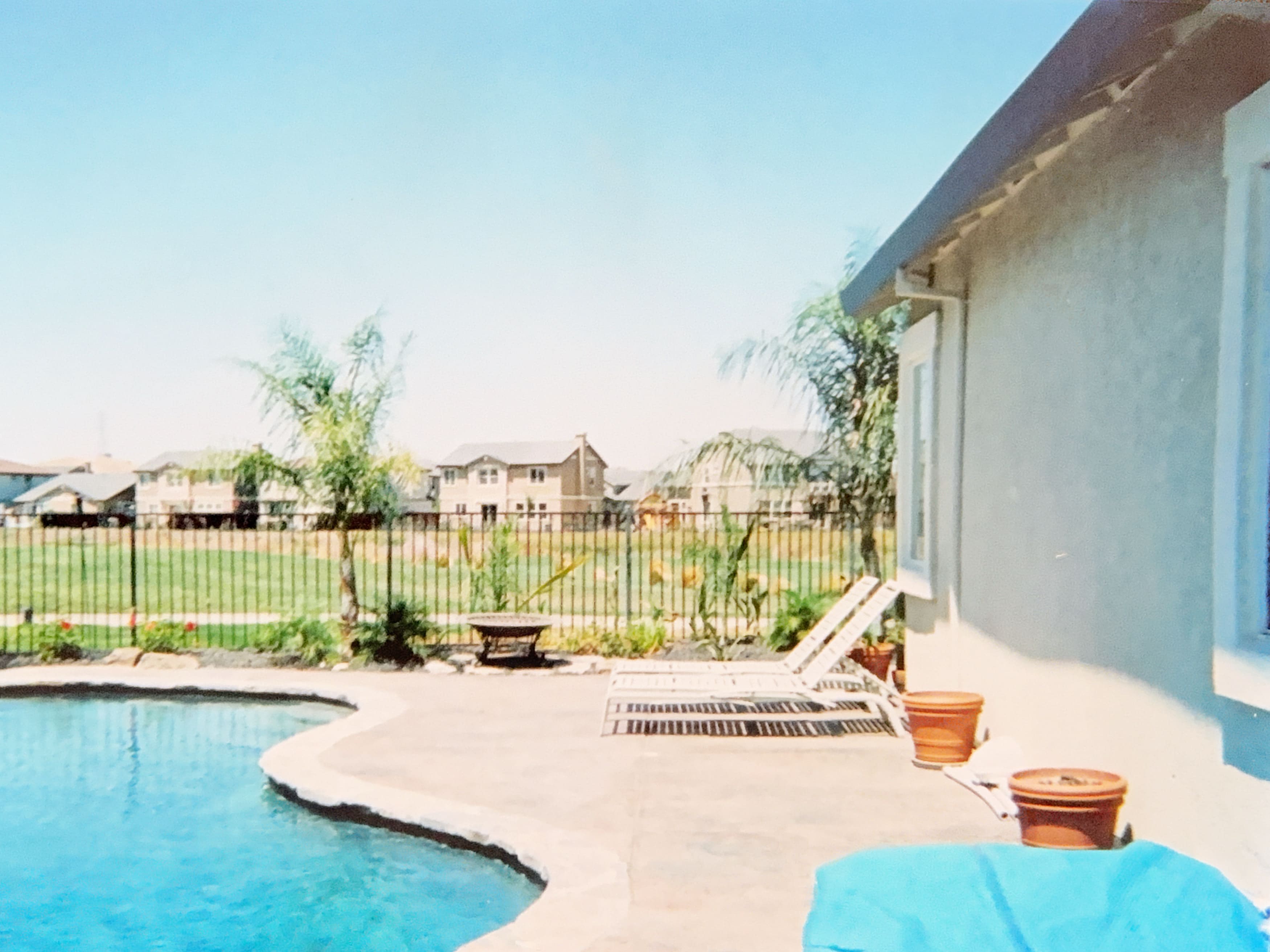 Backyard swimming pool with a concrete deck and lounge chairs