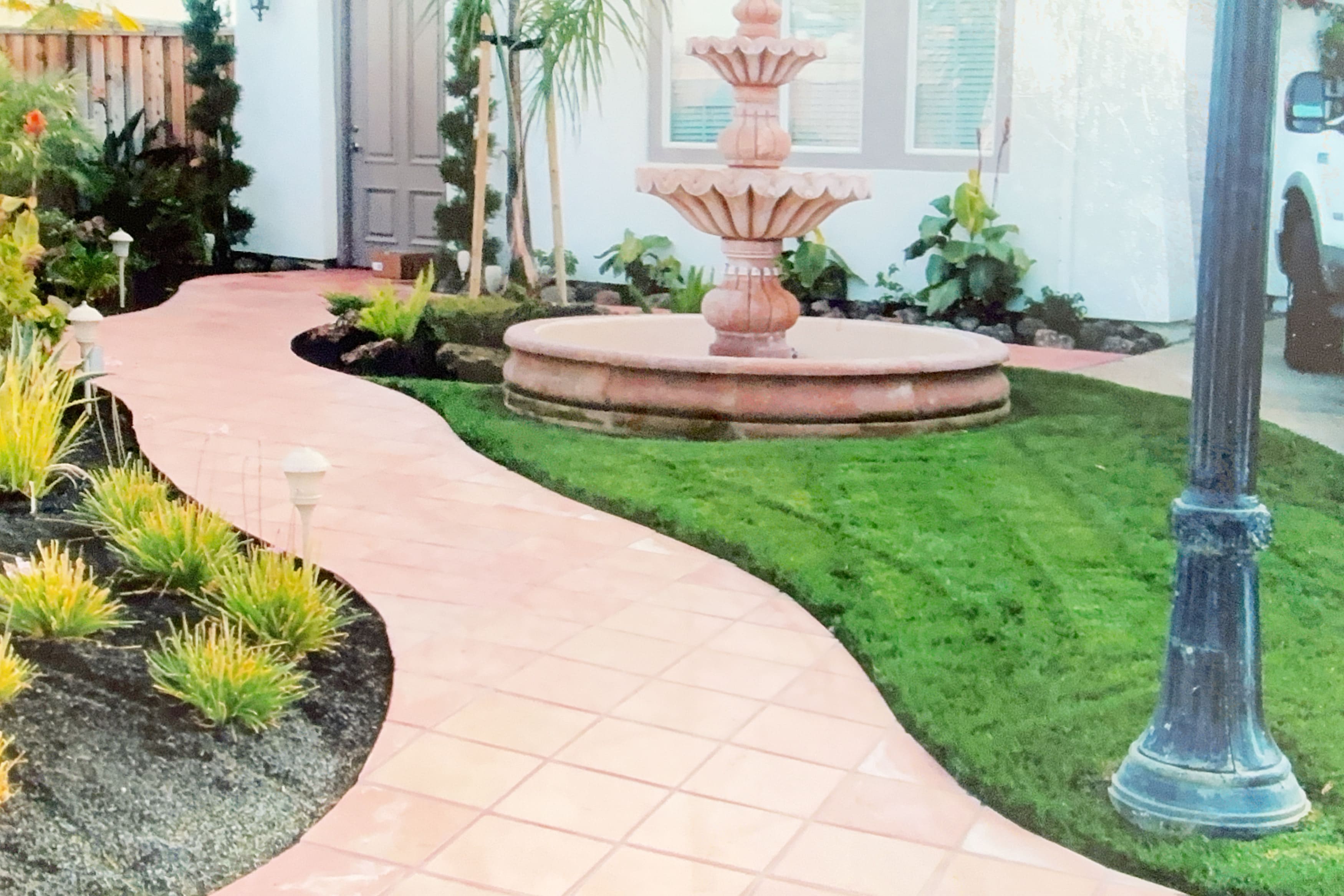 Concrete pathway leading to a classic tiered fountain