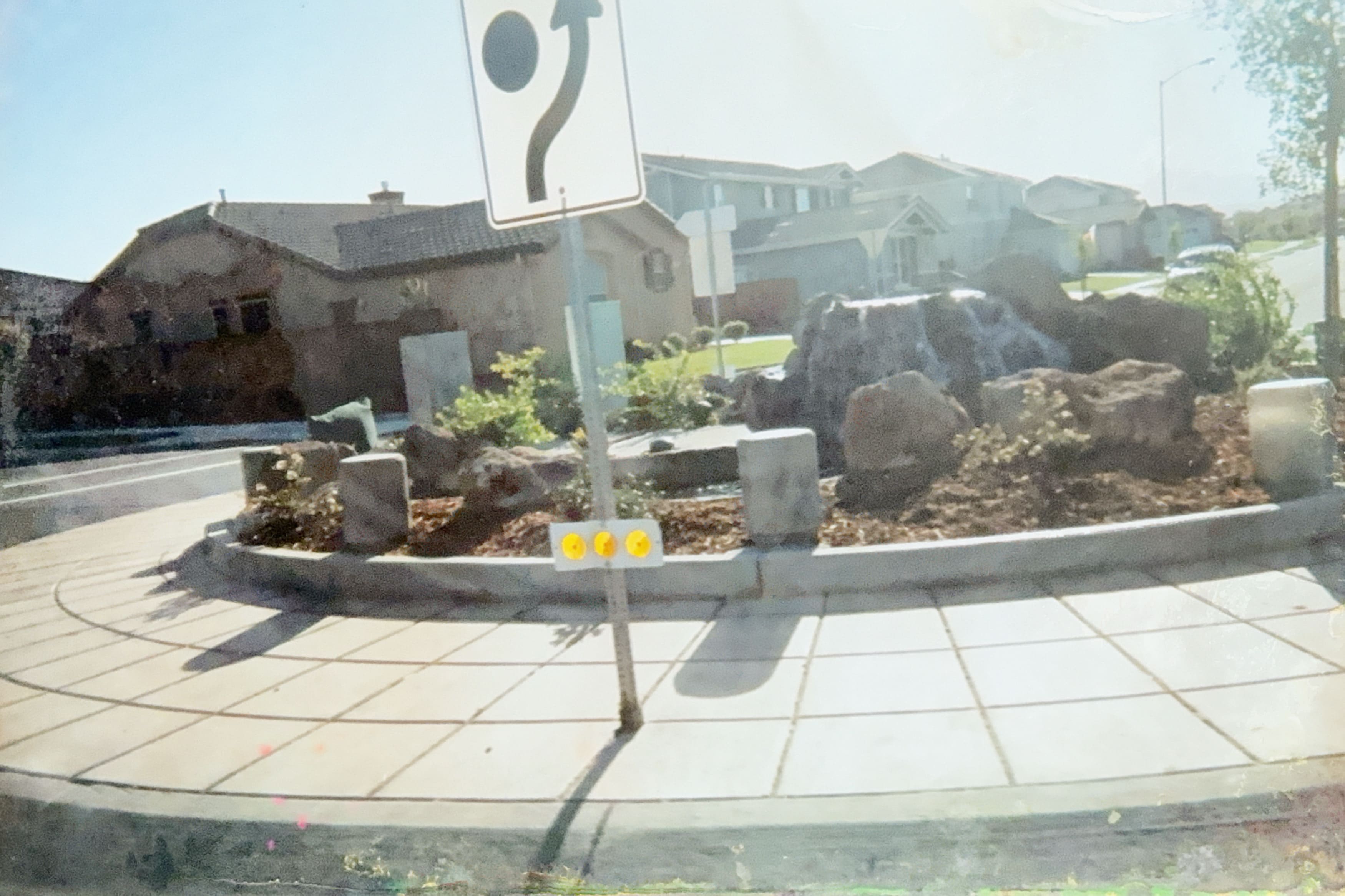 Custom rock landscaping and waterfall feature in a roundabout