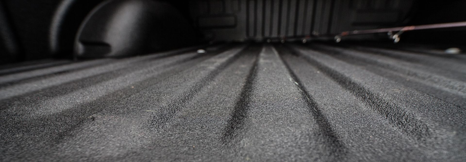 Textured black spray-in bed liner coating a pickup truck bed