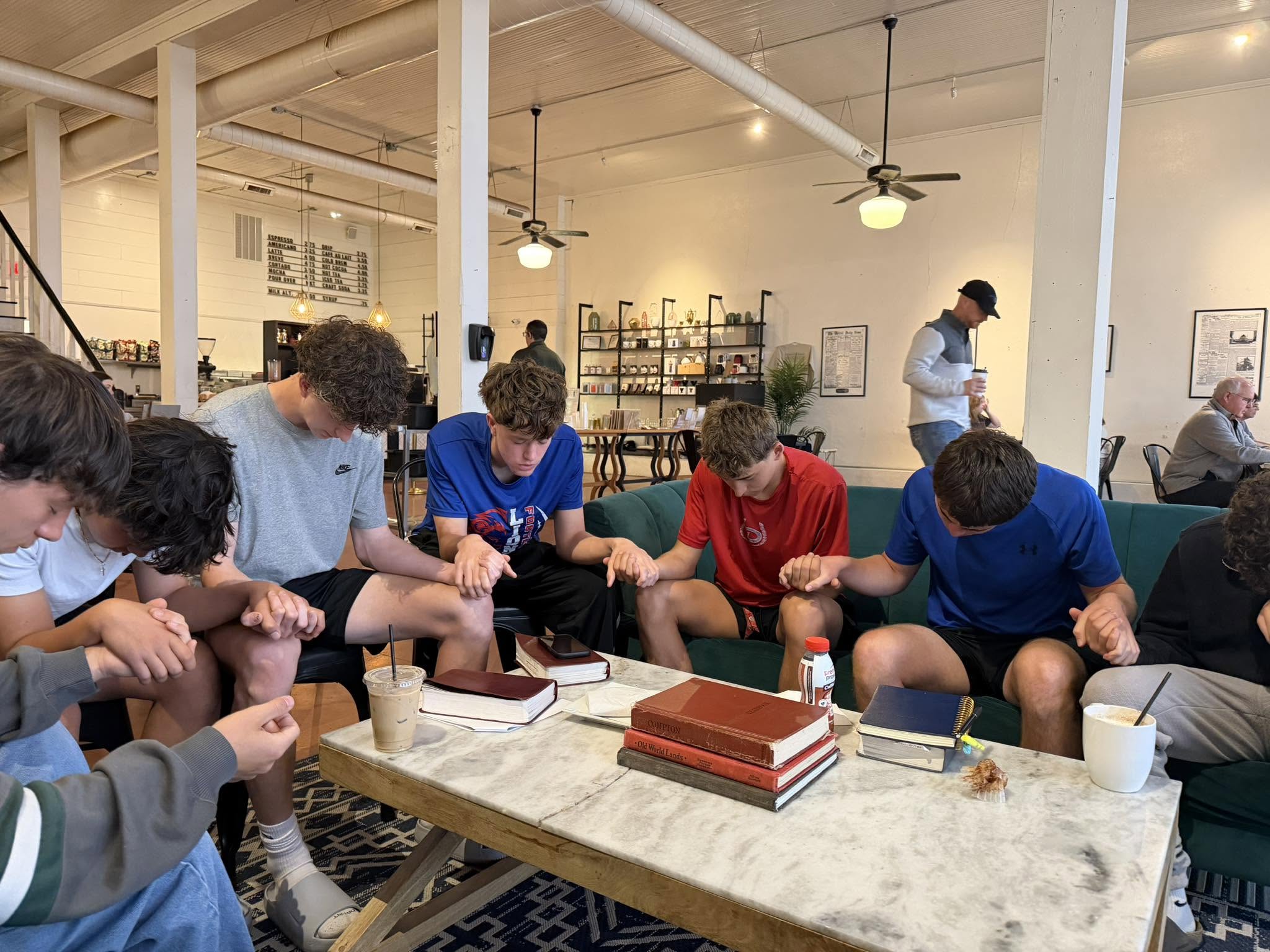 Young men gathered in prayer at the Opera House coffee shop