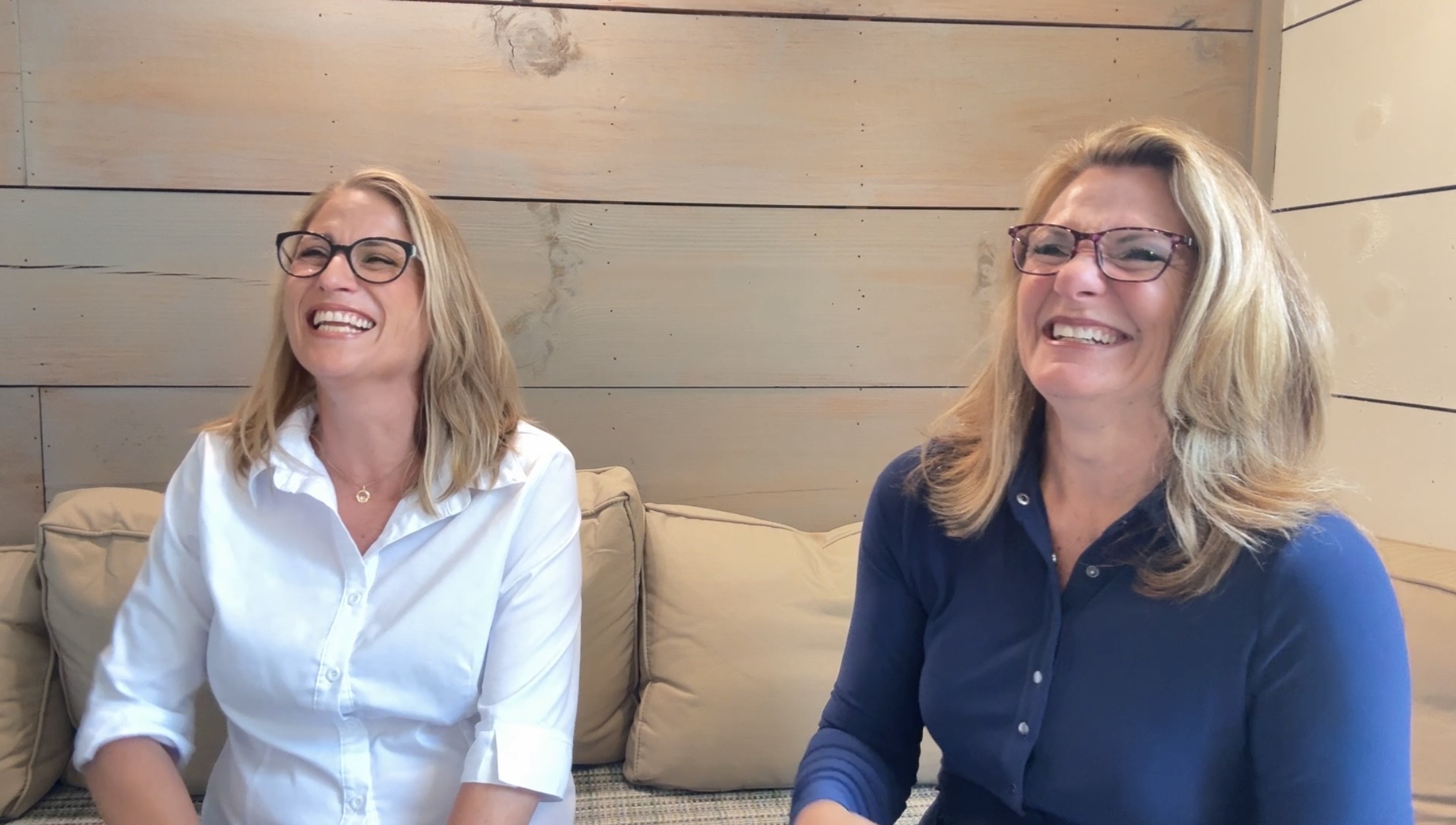 Sharon and Tiffany laughing together on a couch at Your Brand Build