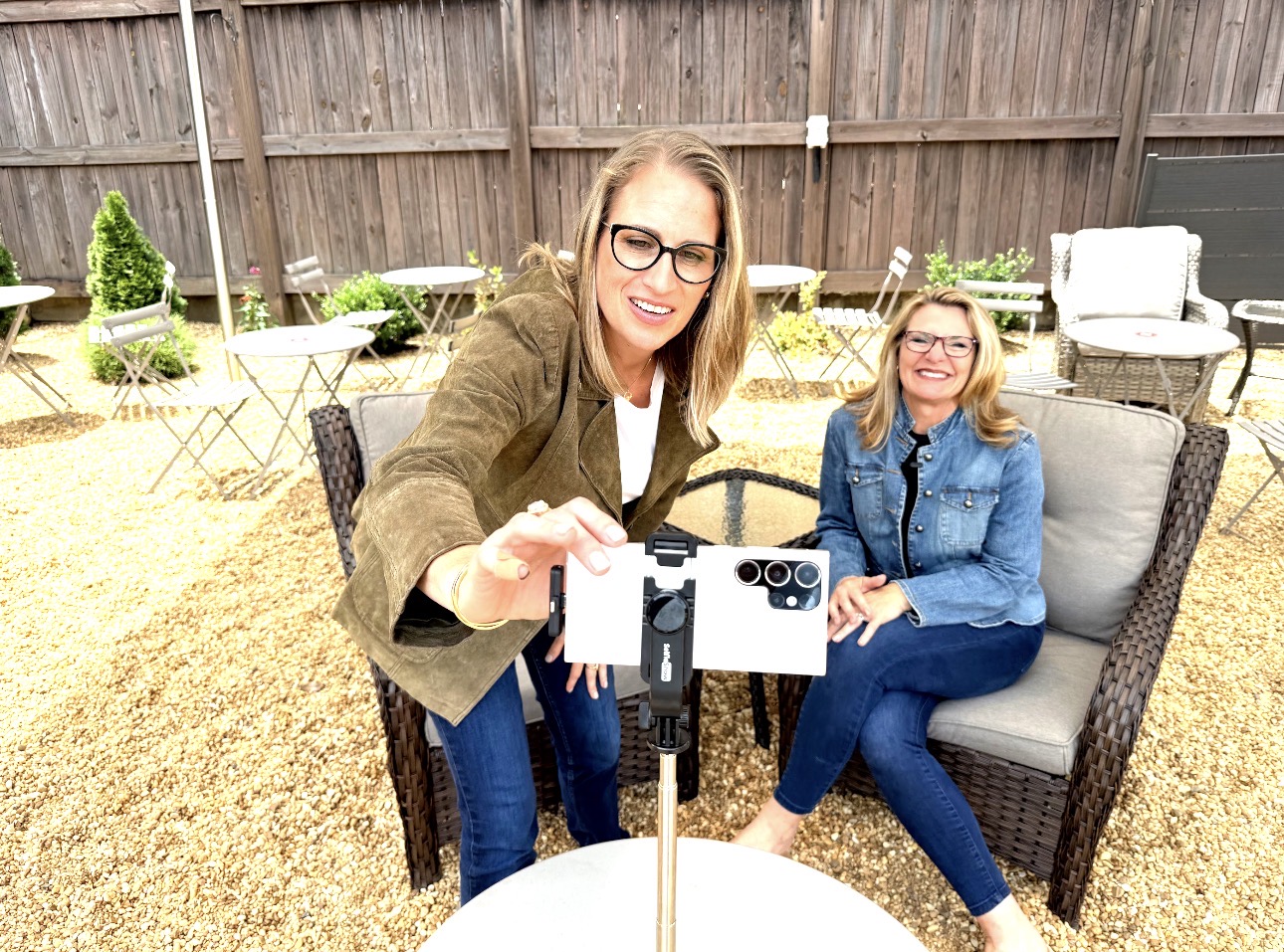Sharon and Tiffany taking an outdoor selfie video setup on patio