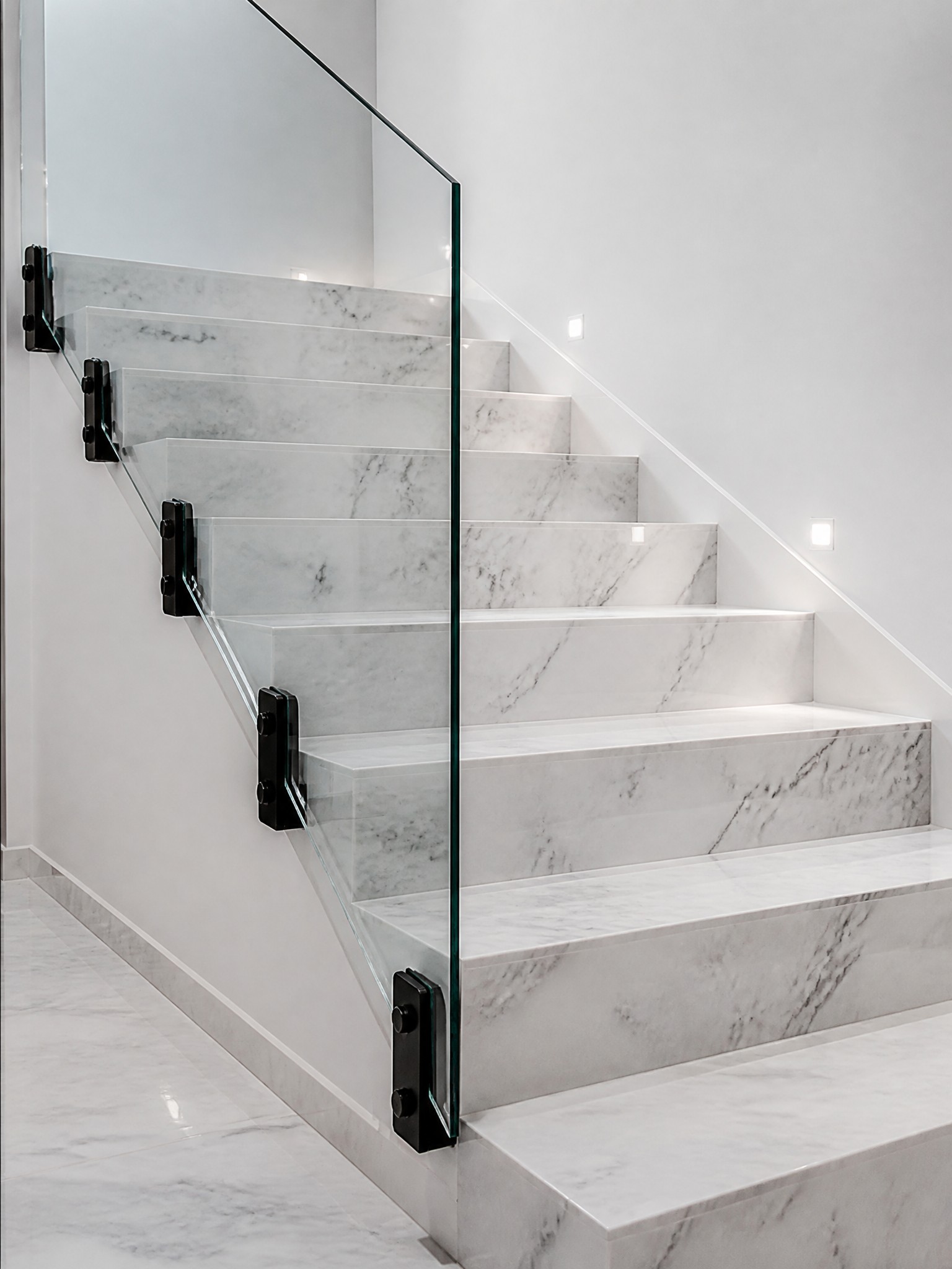 Marble staircase with glass railing in luxury villa