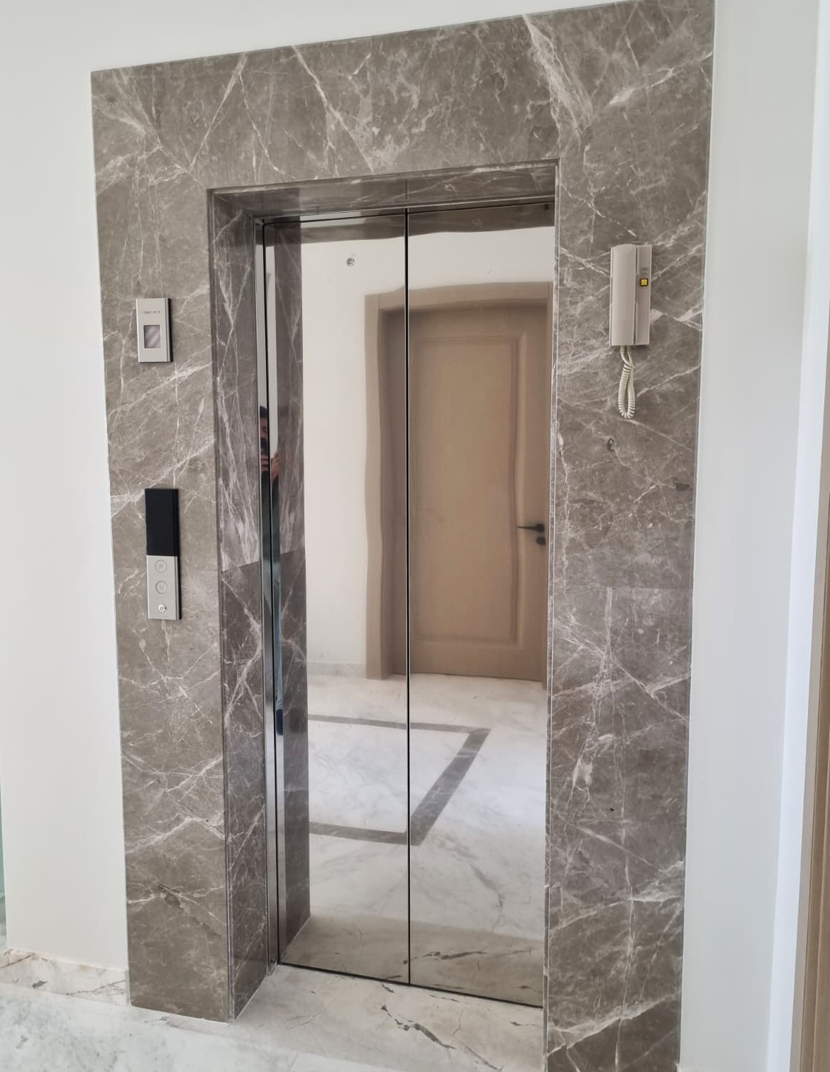 Elevator area with marble wall cladding in private residence