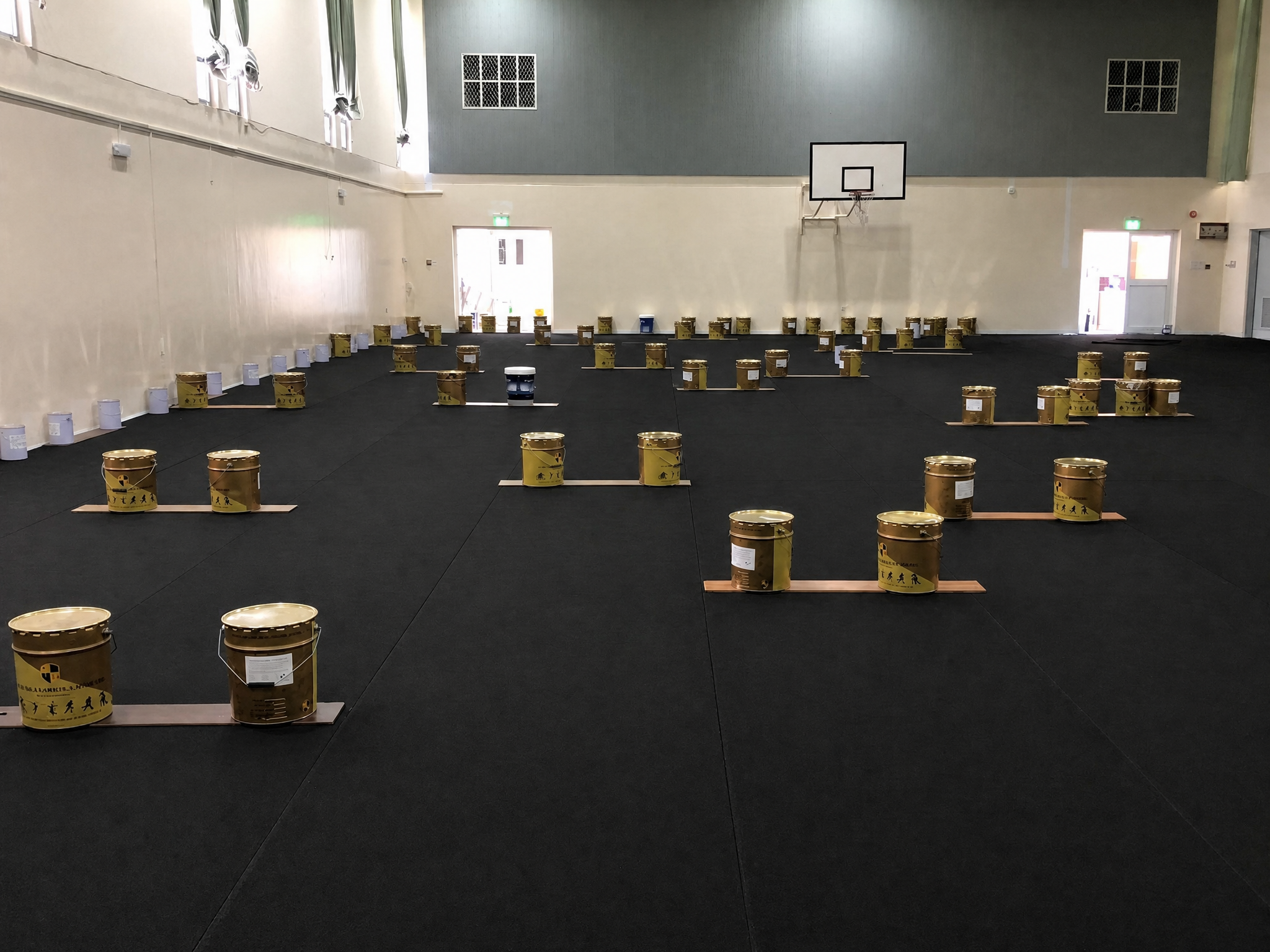PU sports flooring materials preparation with rubber mats and coating buckets at Budaiya School