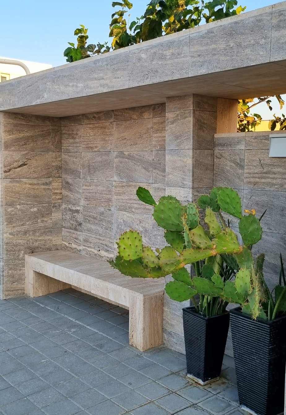 Outdoor seating area with travertine bench and boundary walls