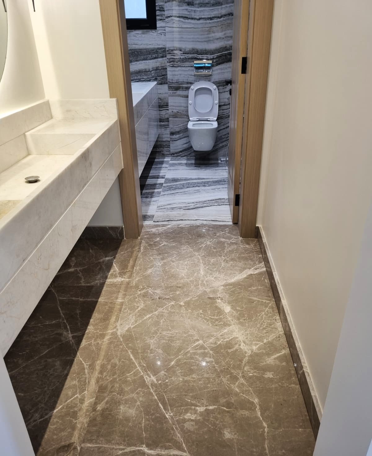 Luxury bathroom with marble vanity, walls, and custom-made basin