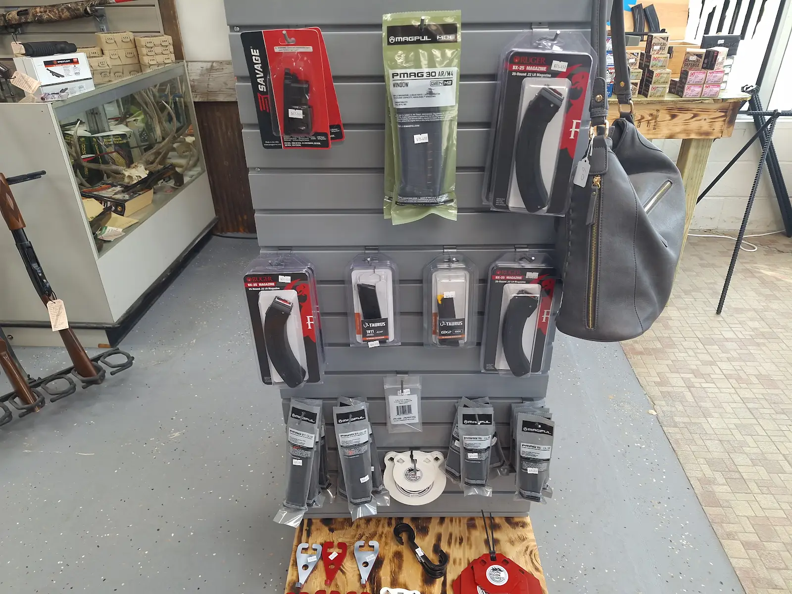 Packaged firearm accessories and magazines displayed on a retail stand inside Freedom Forever Firearms in Manistique, Michigan.