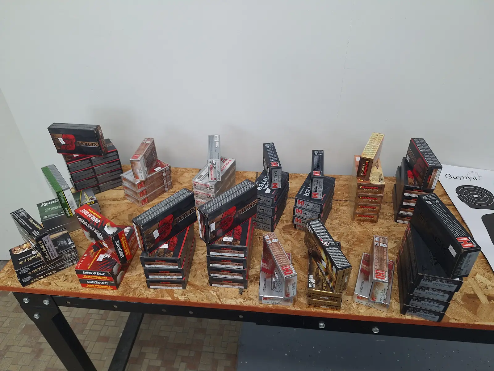 A wide selection of ammunition boxes displayed on wooden shelves inside Freedom Forever Firearms in Manistique, Michigan.