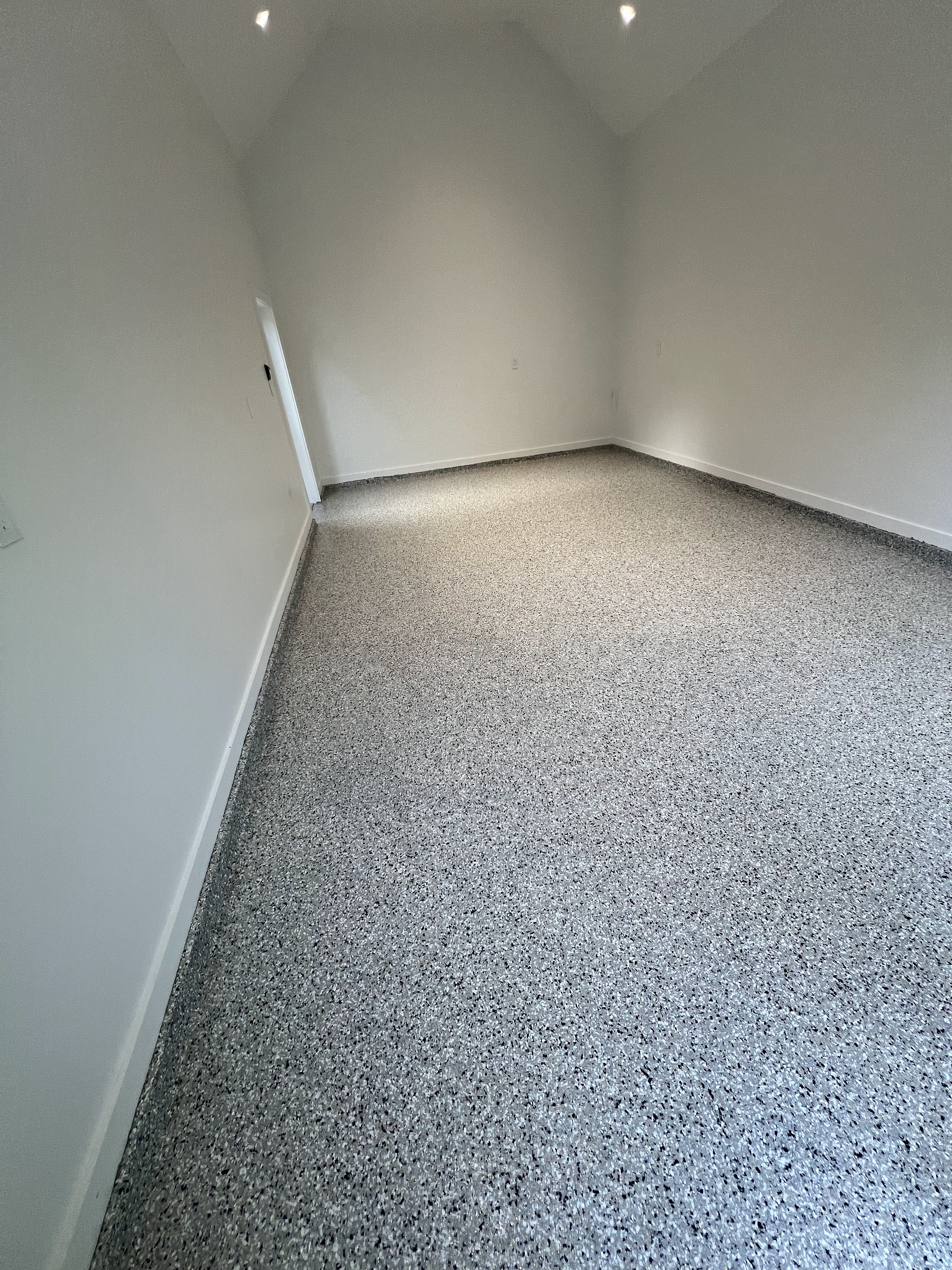 Empty room featuring a seamless flake epoxy floor