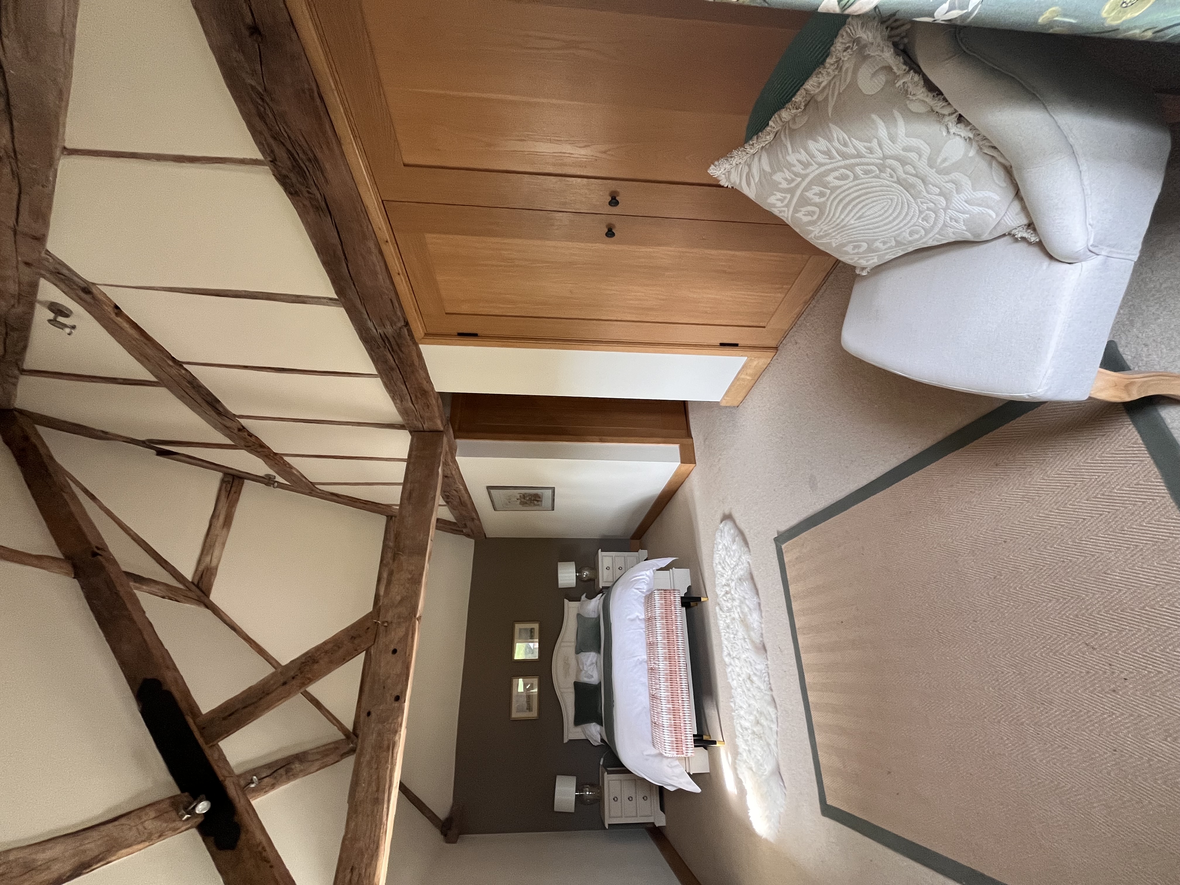 The Pond Room bedroom with vaulted wooden beams and fitted oak furniture
