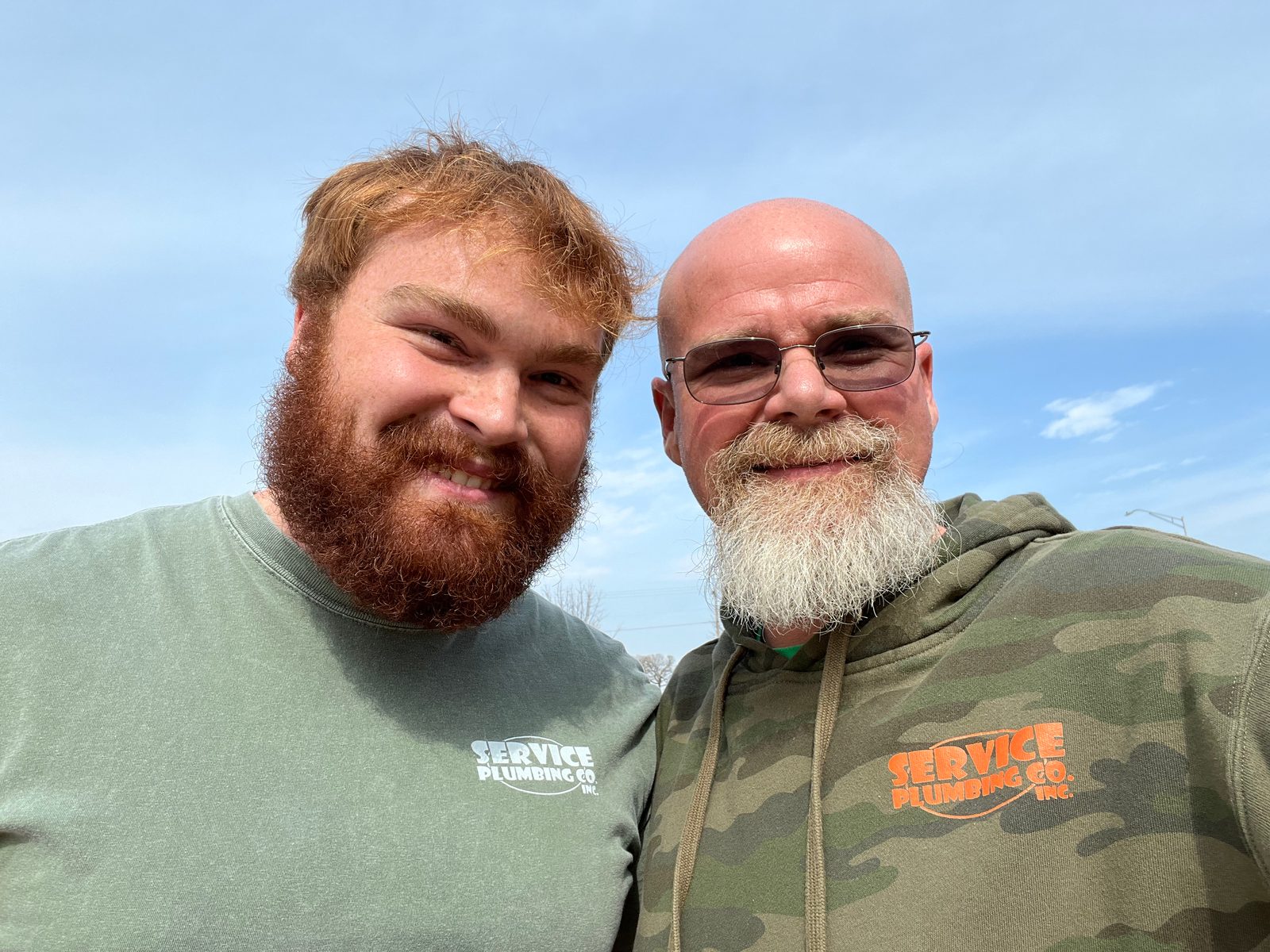 The Service Plumbing crew - two team members in branded apparel
