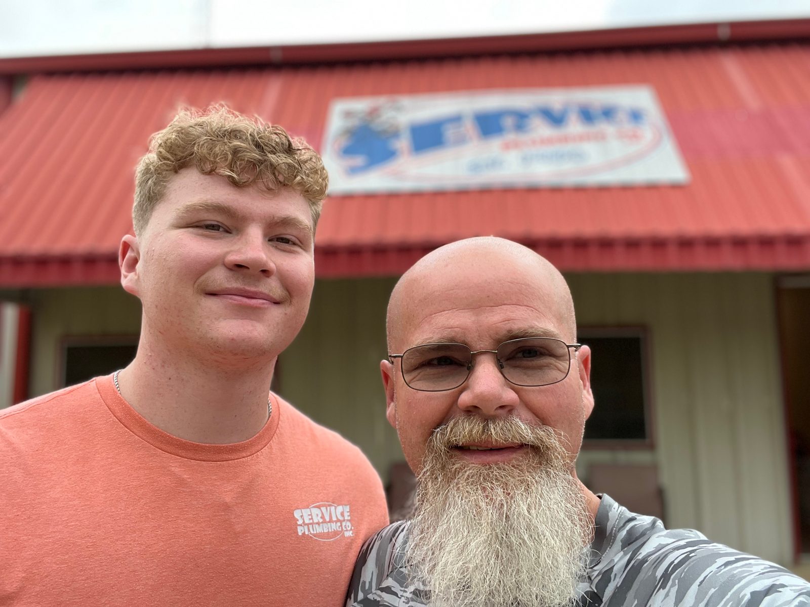 Service Plumbing team members in front of shop