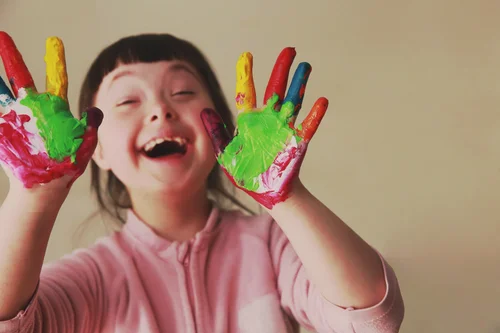 Child with painted hand smiling