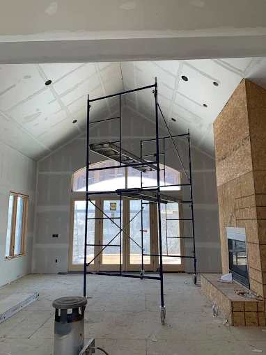 Vaulted ceiling drywall hanging in great room with fireplace