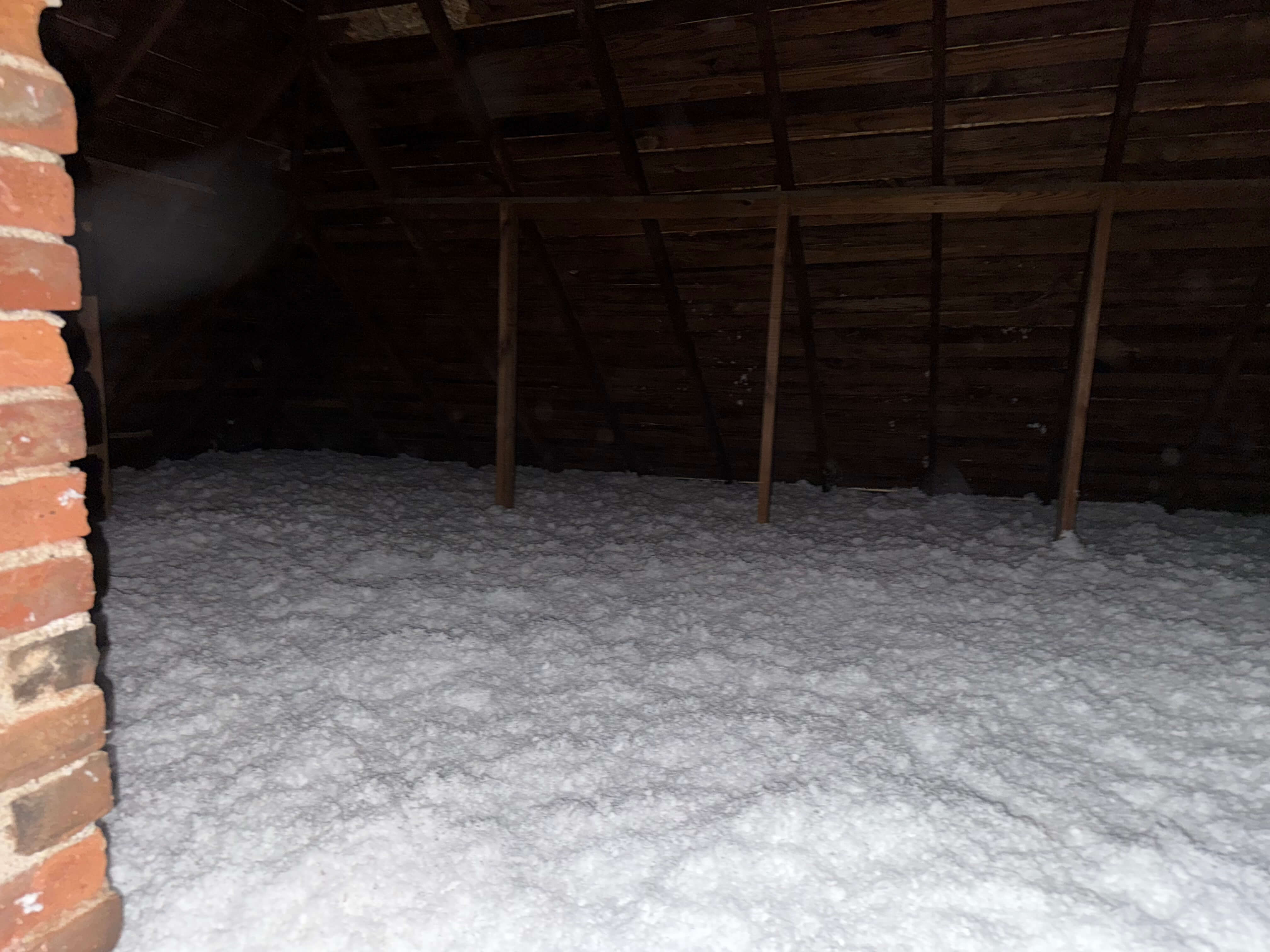 Thick layer of fresh blown-in white insulation in an attic