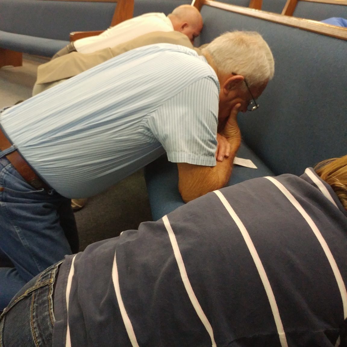 Men praying in pews