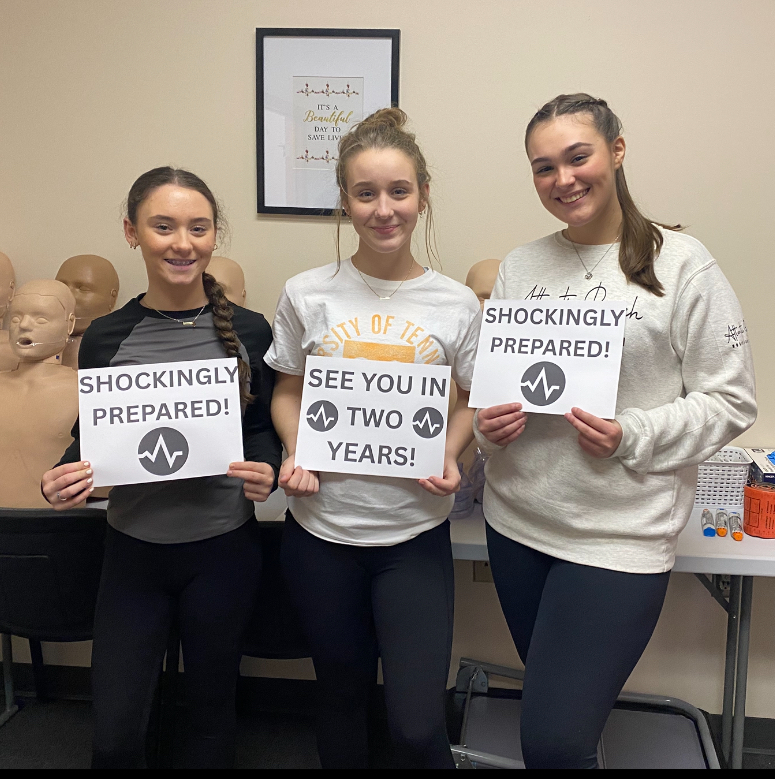 Students holding CPR signs