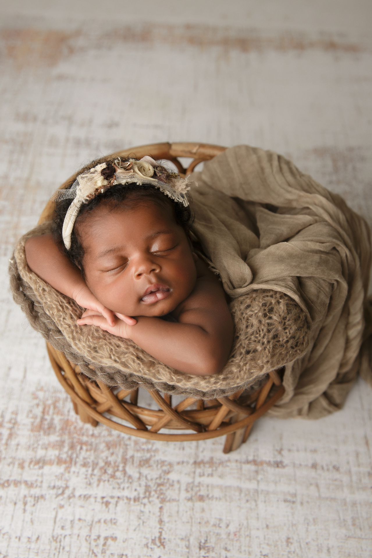 Peaceful newborn baby resting in a woven basket