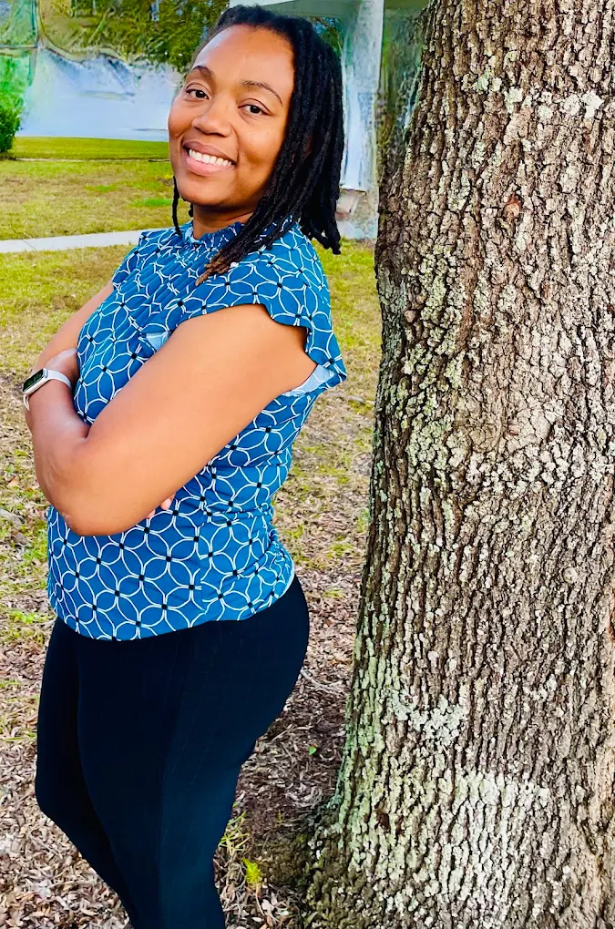 Roxanne Spencer, Certified Nurse Midwife, standing outdoors by a tree