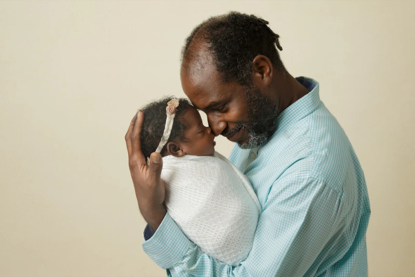Father tenderly holding his swaddled newborn