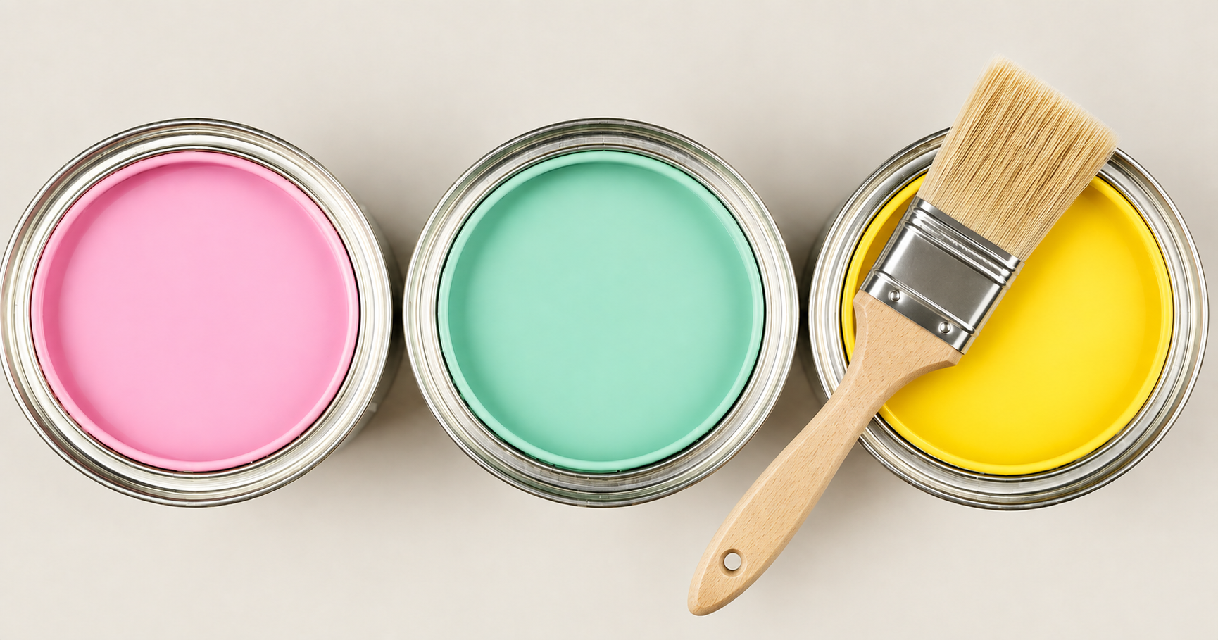 Three paint cans with pink, turquoise, and yellow paint with a paintbrush