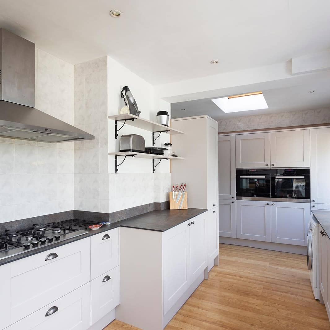 Classic white shaker kitchen installation featuring contrasting dark worktops and elegant styling