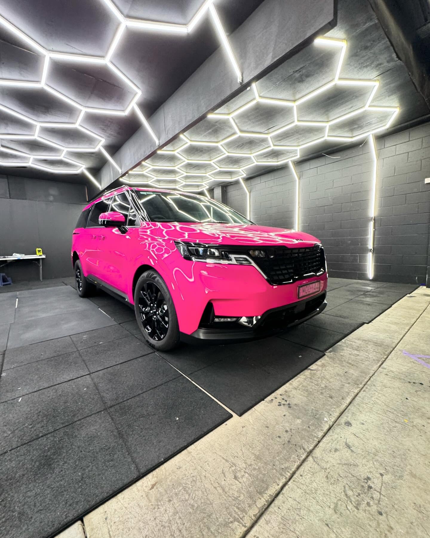 Bright pink wrapped Kia Carnival in the Master Wraps Townsville studio