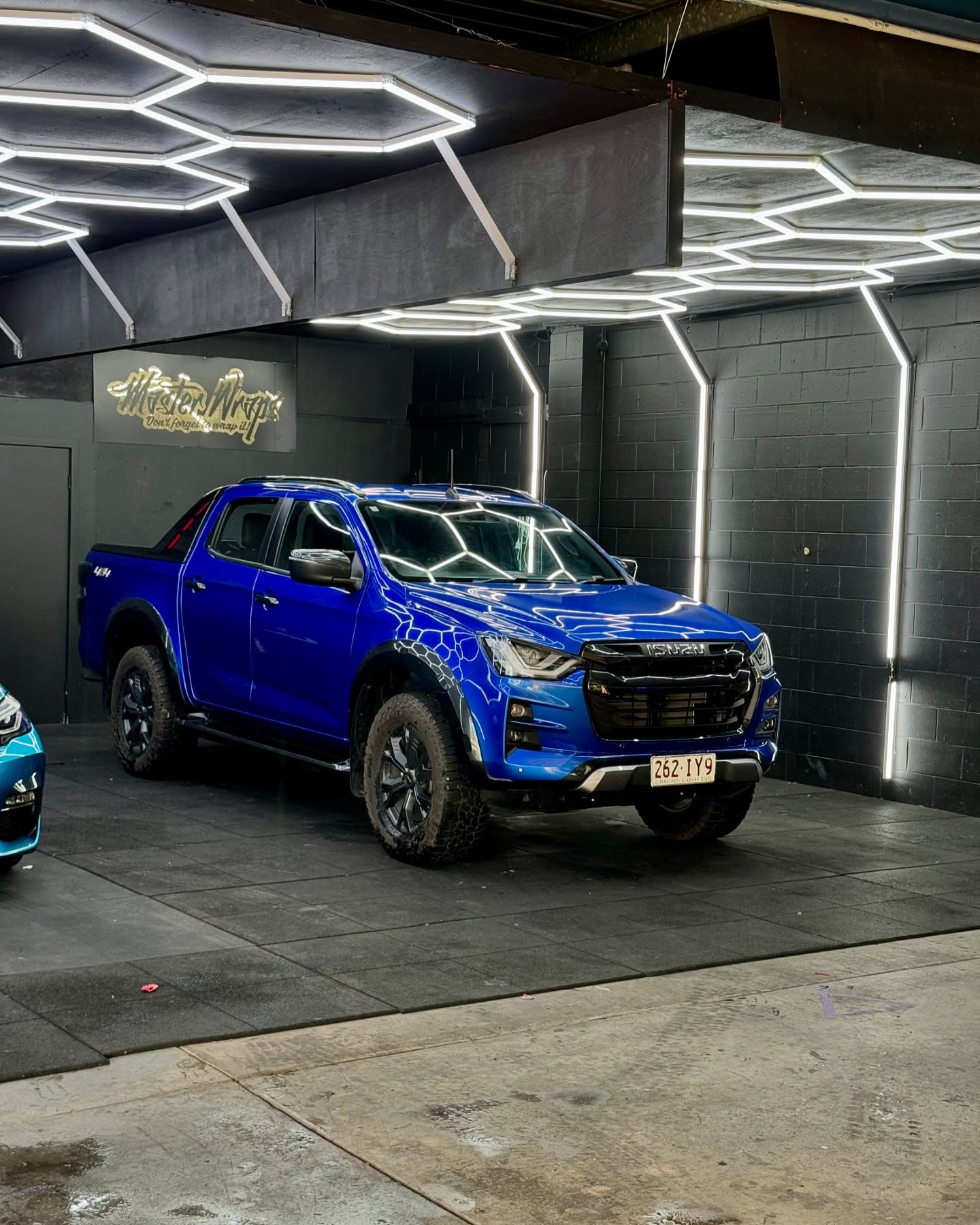 Gloss blue Isuzu D-Max dual cab ute parked inside the Master Wraps Townsville studio