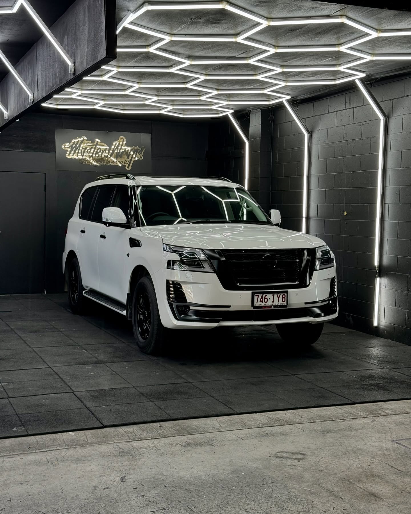 White Nissan Patrol Y62 with blackout package inside the Master Wraps studio